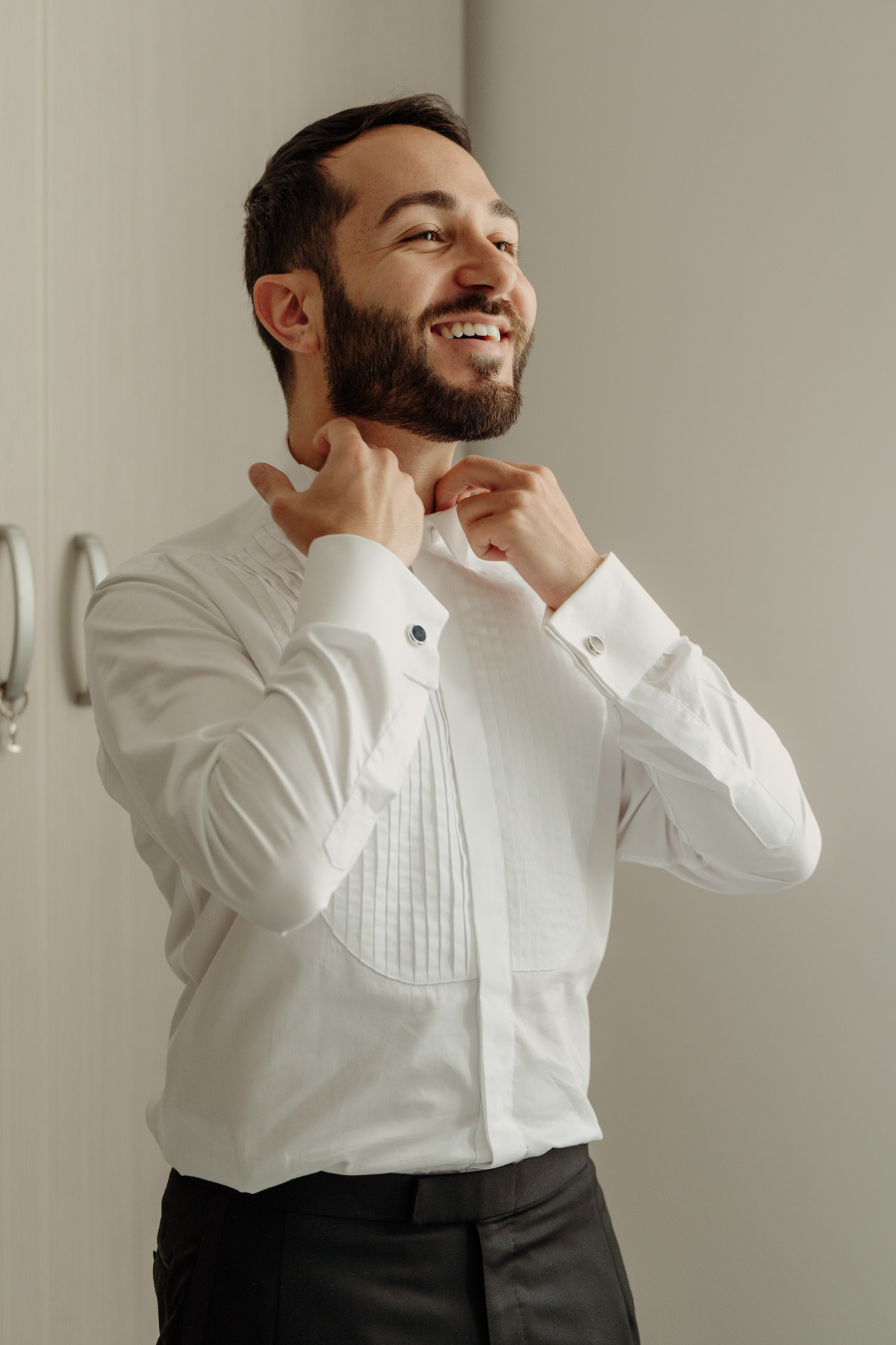 Lo sposo si sistema il colletto, sorridendo