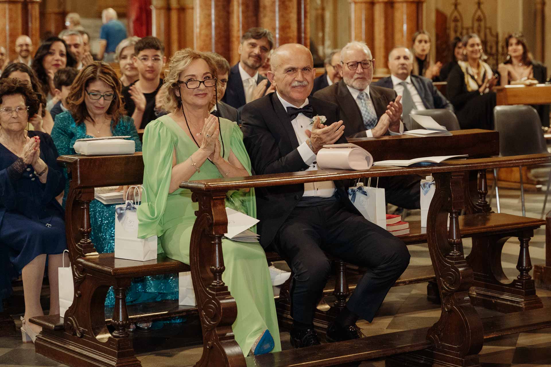 Gli invitati applaudono tra le panche
