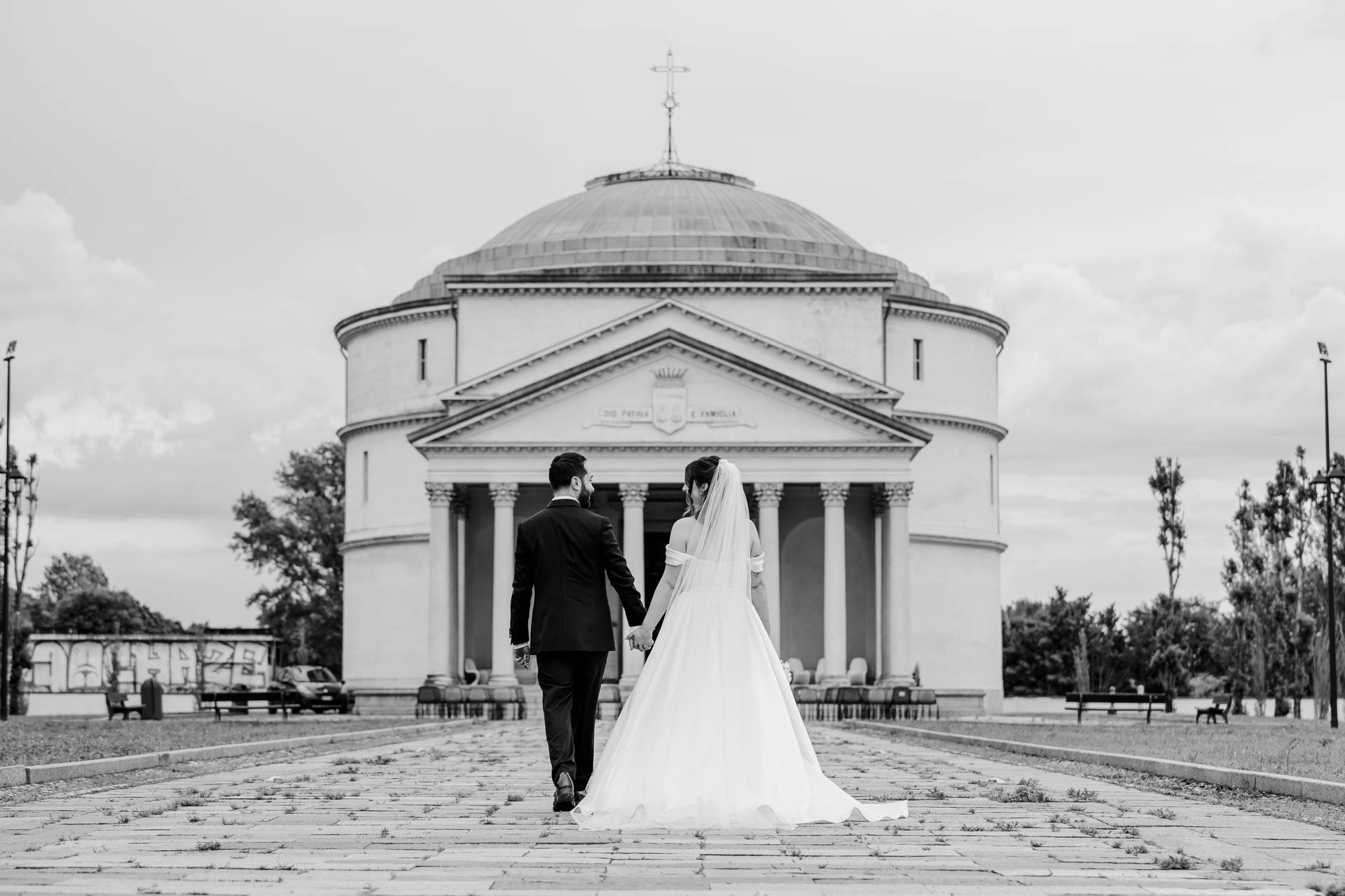 In bianco e nero, gli sposi di spalle camminano verso il mausoleo