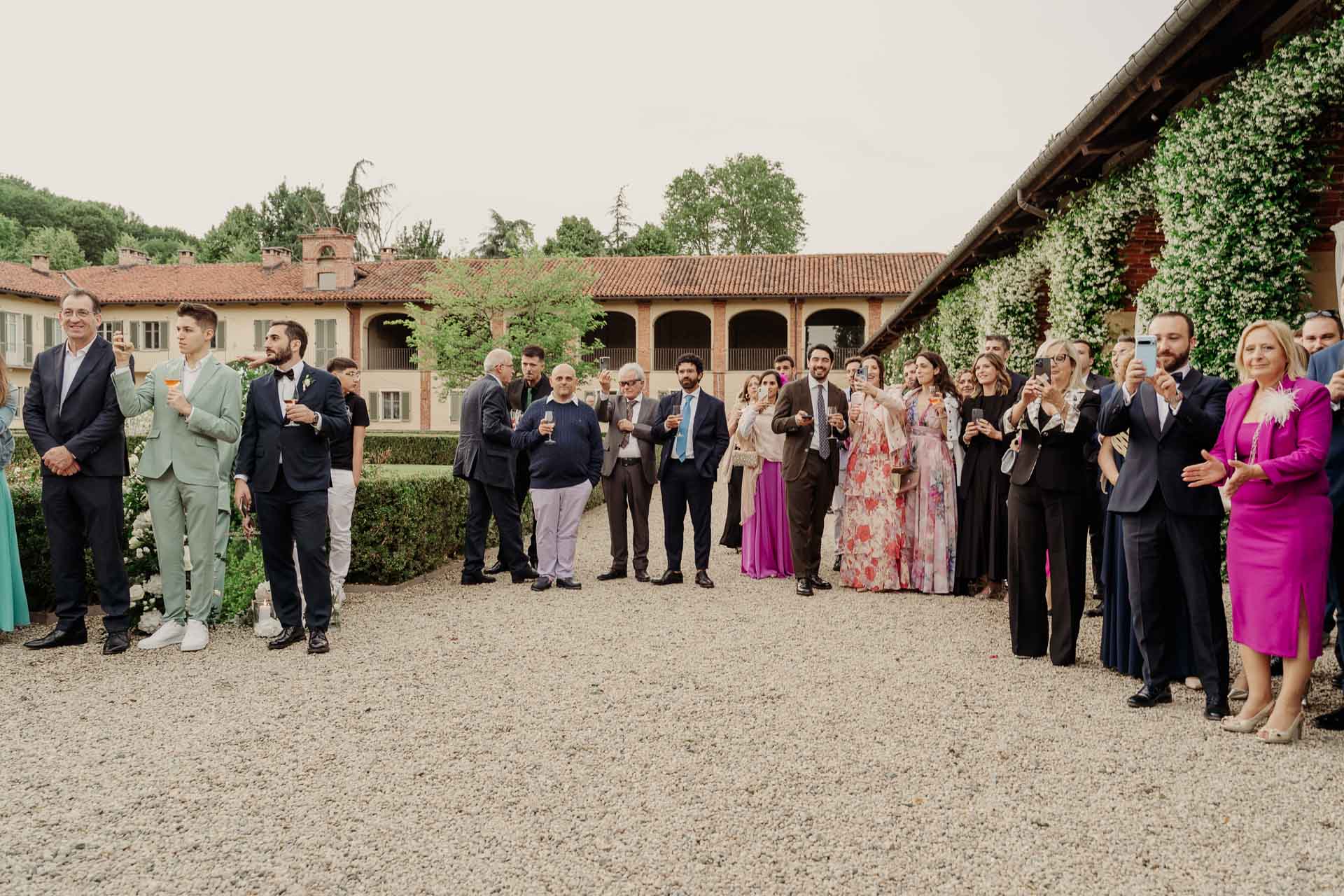 Gli invitati aspettano gli sposi nella corte della tenuta