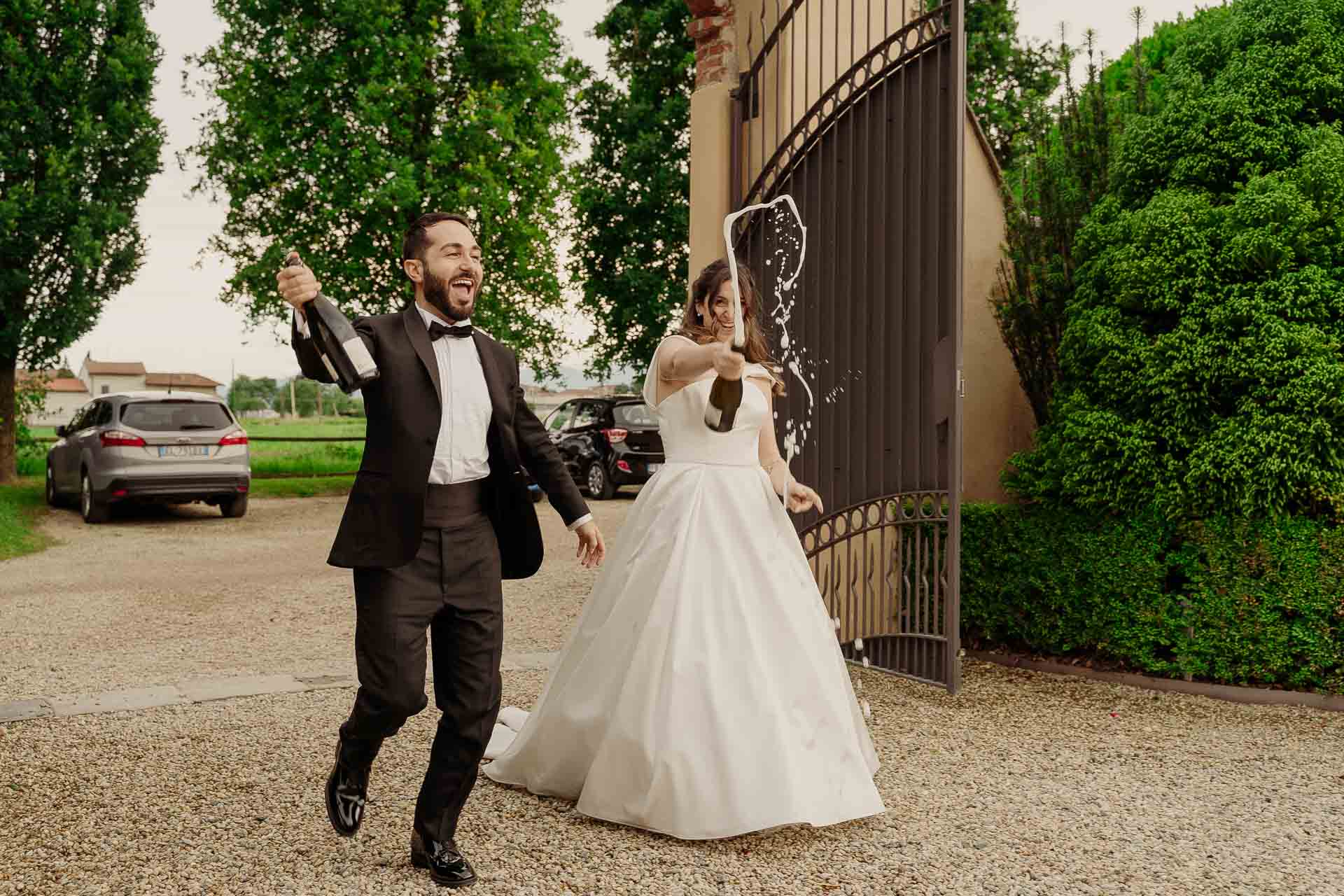 Gli sposi entrano dal cancello stappando lo spumante