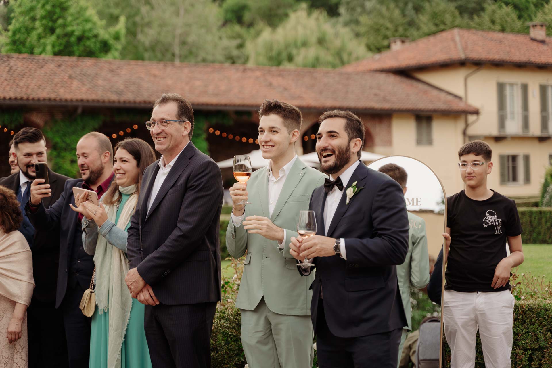 Gli amici ridono e brindano nella corte