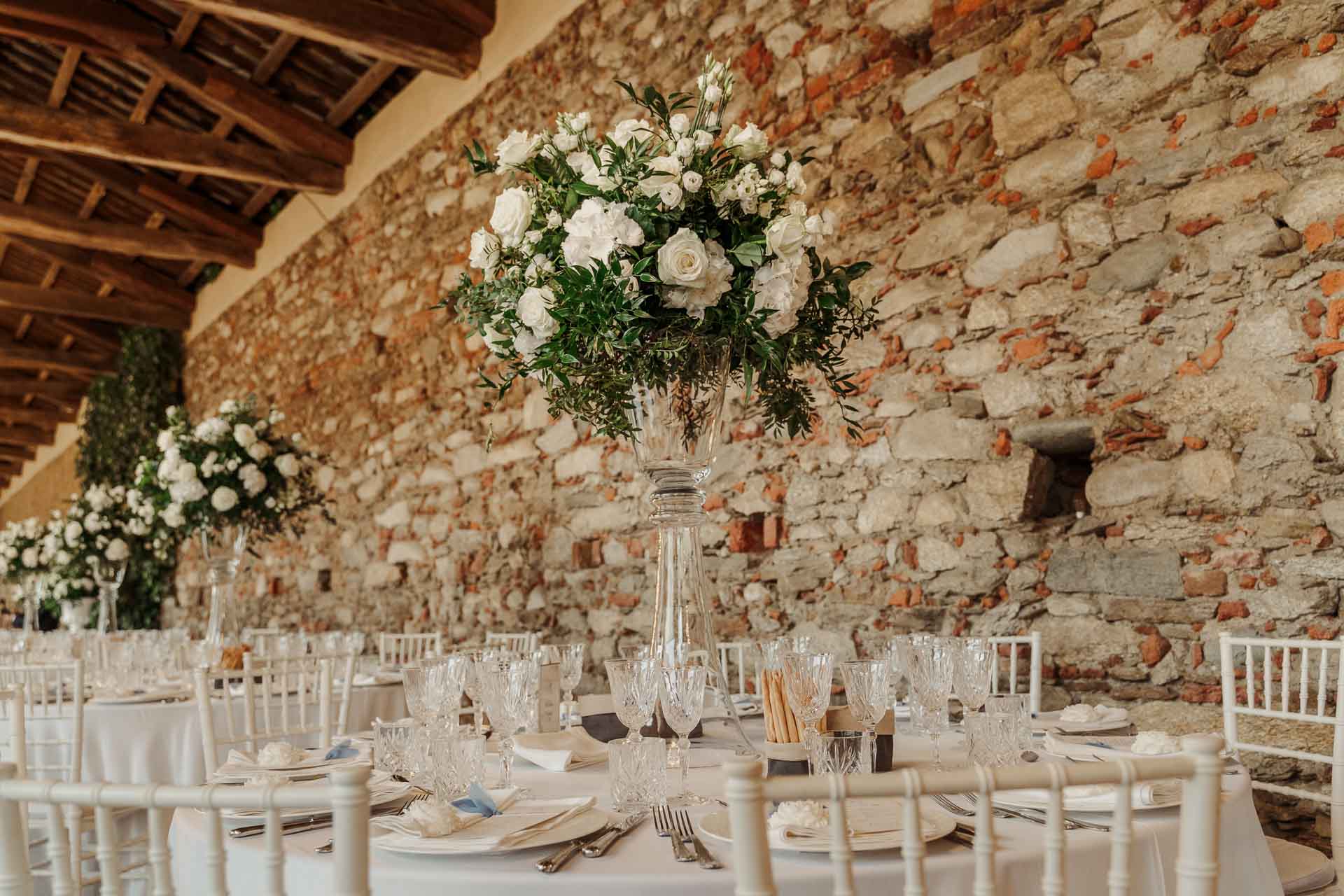 Il muro di pietra del salone e i fiori sui tavoli