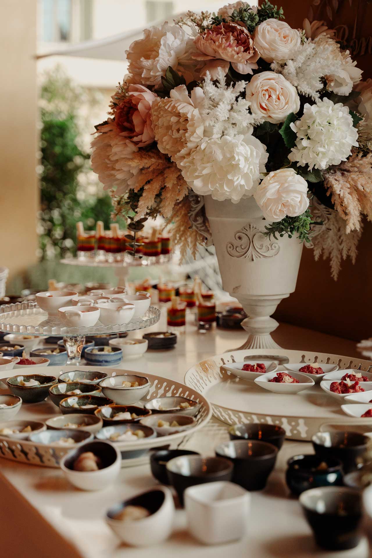 Il buffet sotto il portico, con un grande vaso di fiori