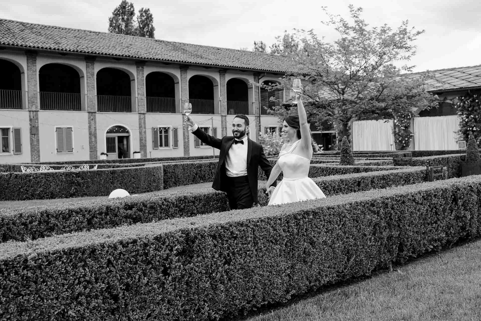 In bianco e nero, gli sposi salutano tra le siepi del giardino