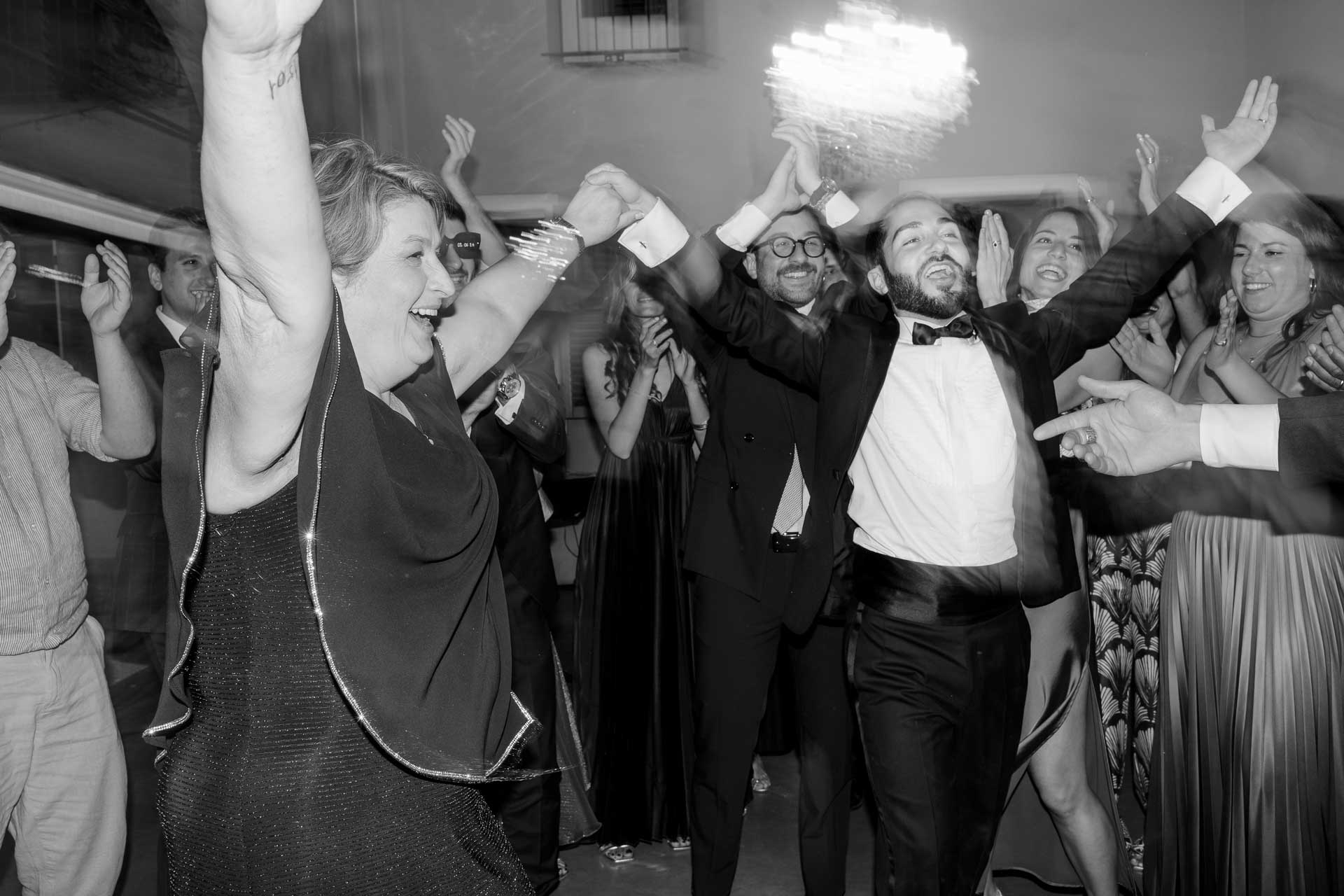 In bianco e nero, gli invitati ballano con le braccia alzate