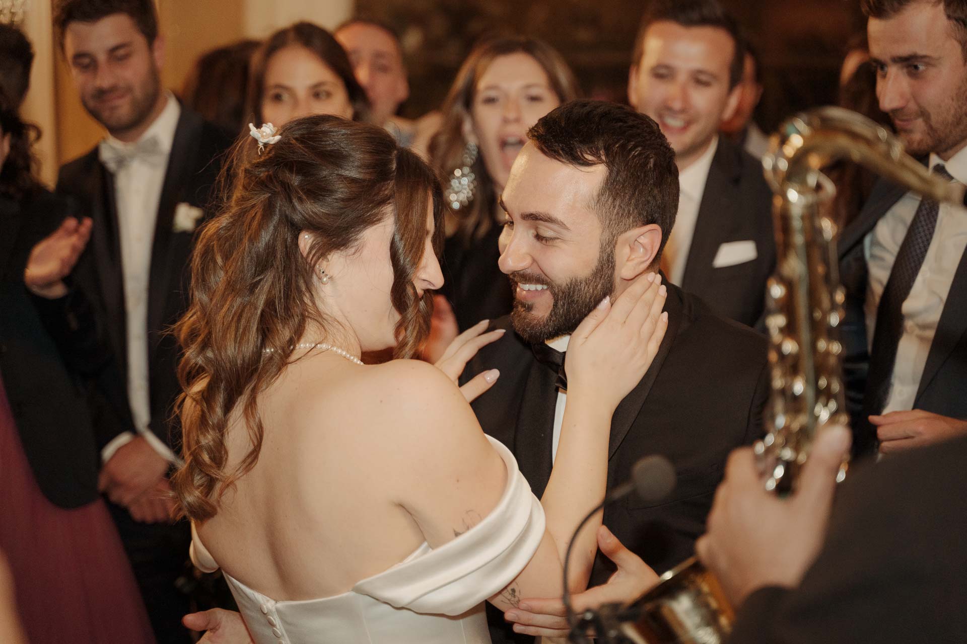 Gli sposi ballano abbracciati accanto al sassofonista