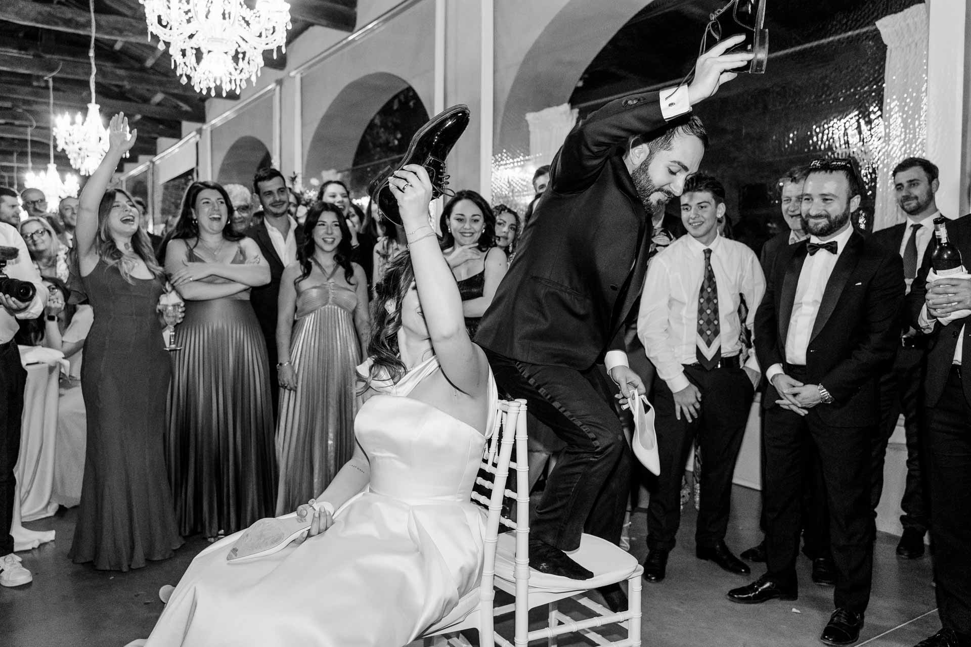 In bianco e nero, lo sposo in piedi sulla sedia accanto alla sposa