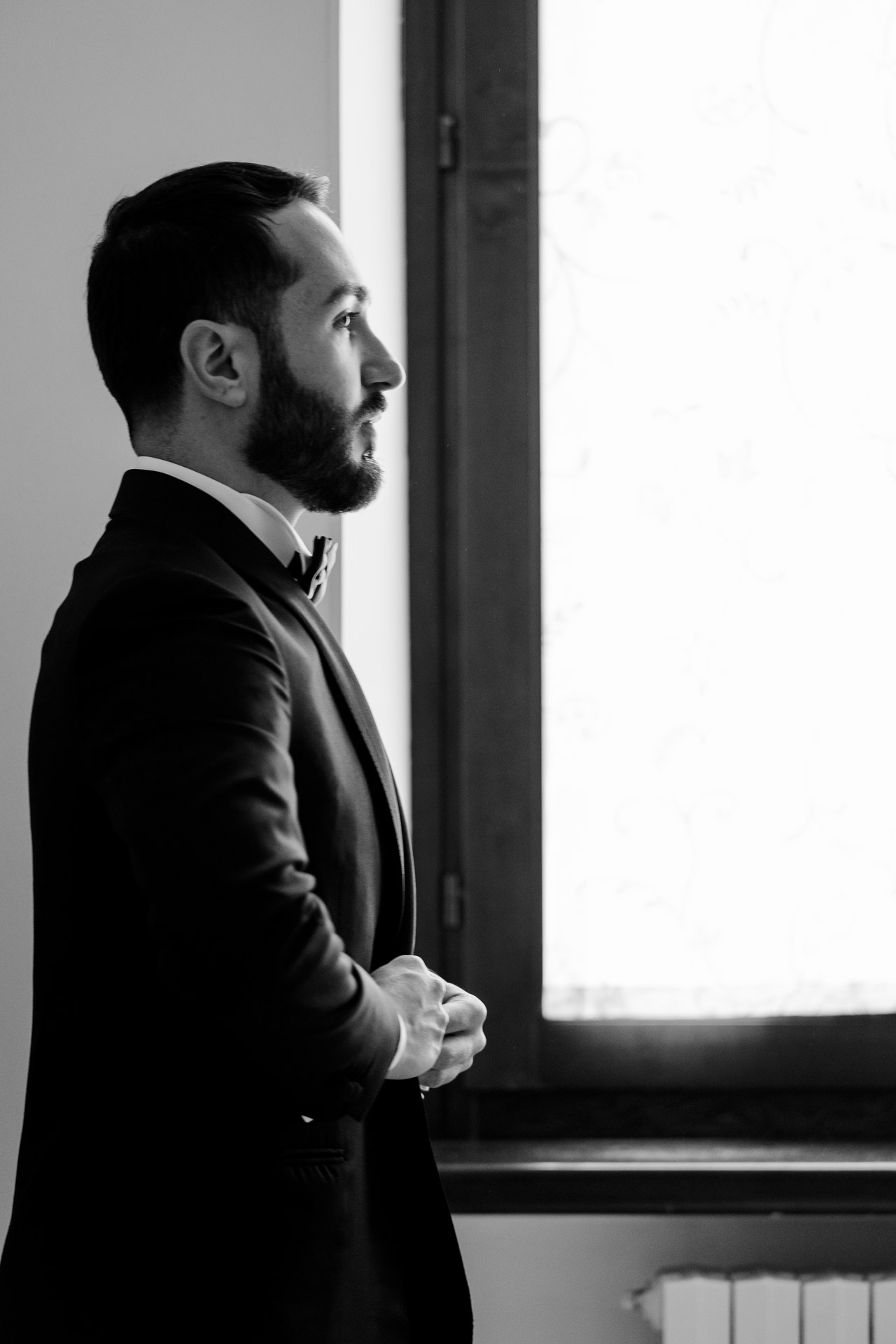 In bianco e nero, lo sposo di profilo alla finestra
