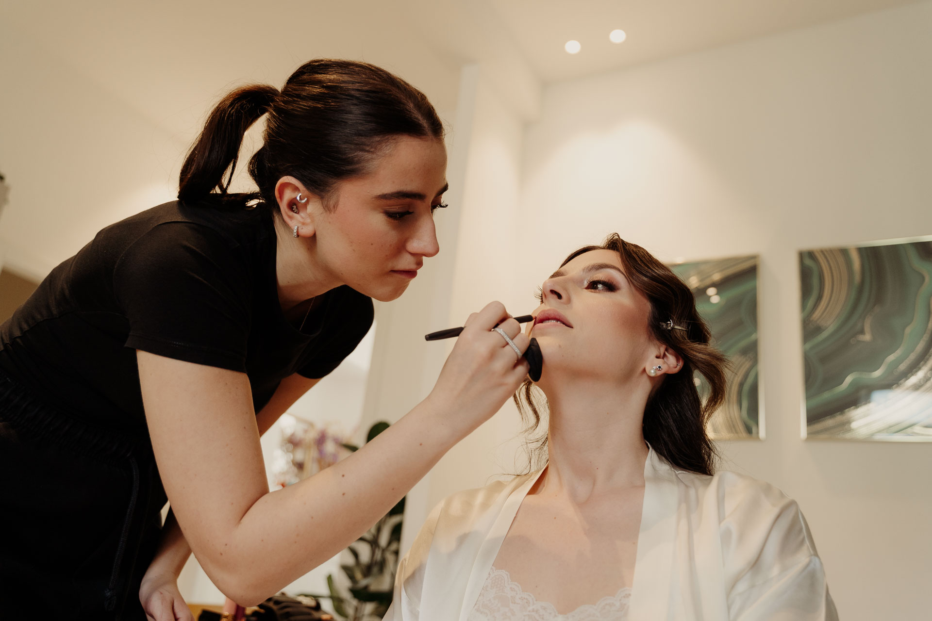 La truccatrice al lavoro sul viso della sposa
