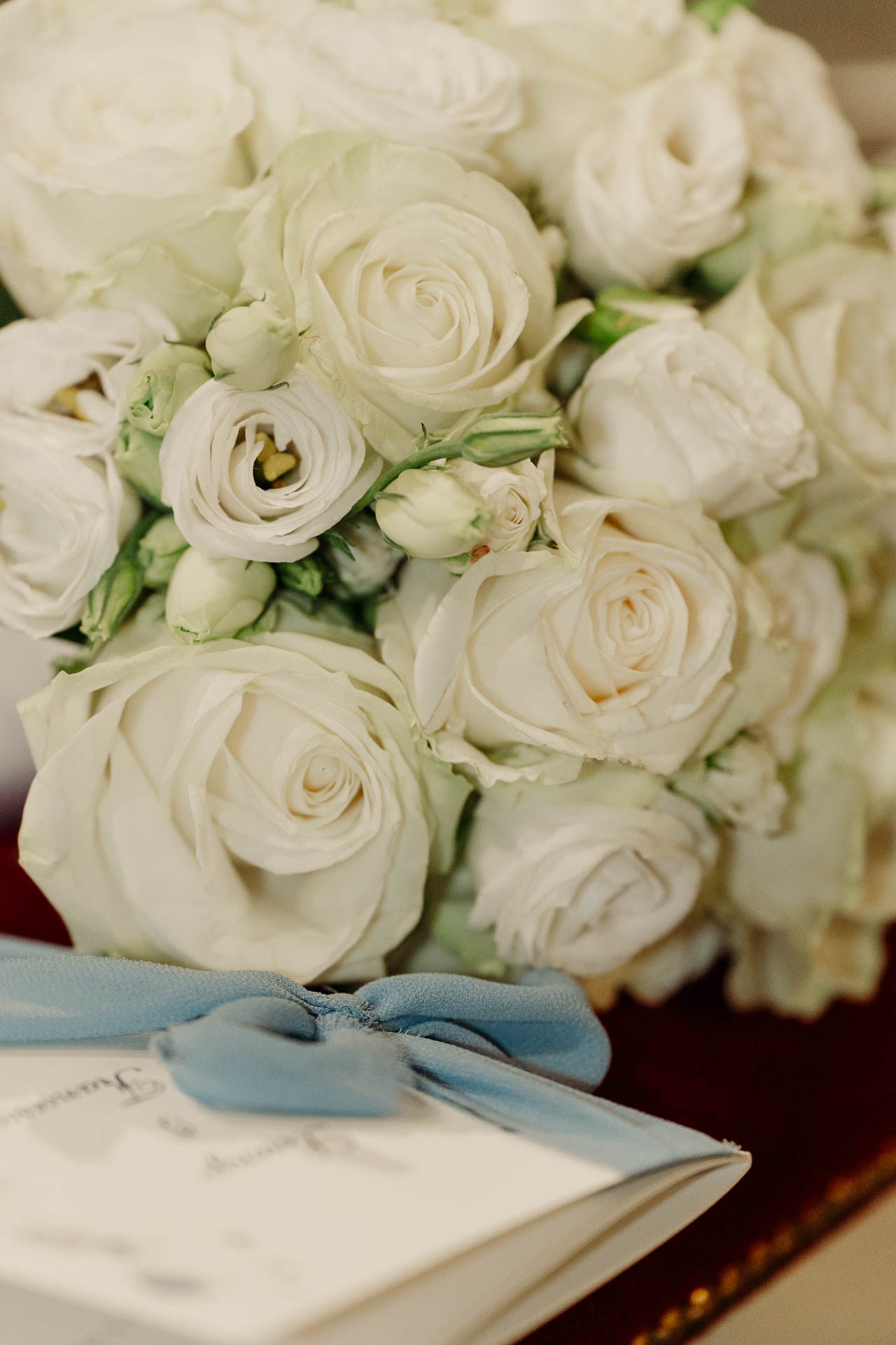 Il bouquet di rose bianche con il nastro azzurro