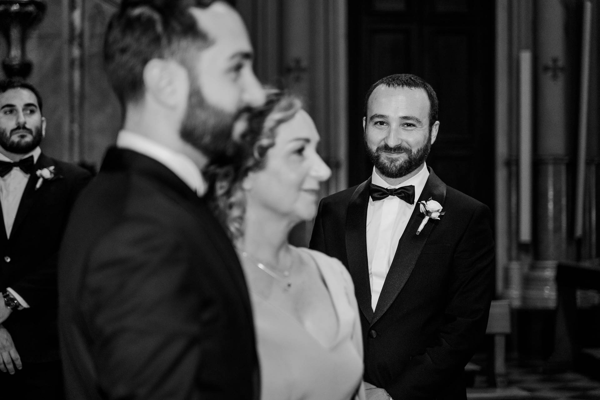 In bianco e nero, lo sposo all'altare con gli amici