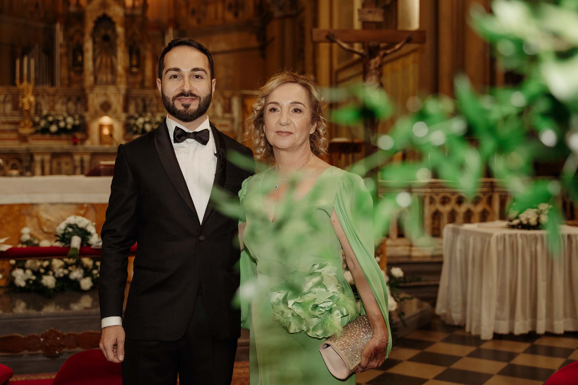 Lo sposo e la signora in verde all'altare, tra i fiori