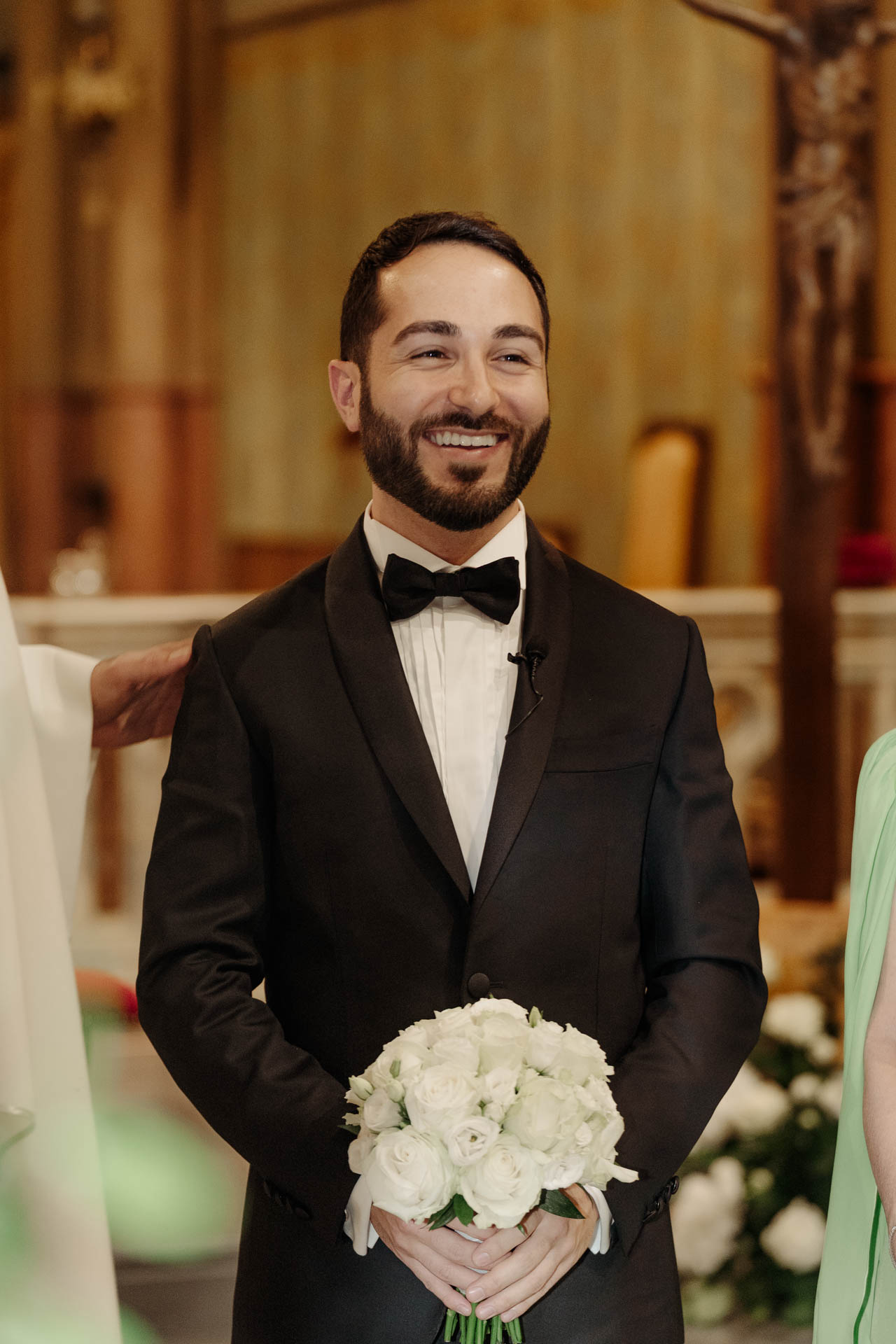 Lo sposo aspetta all'altare con il bouquet in mano
