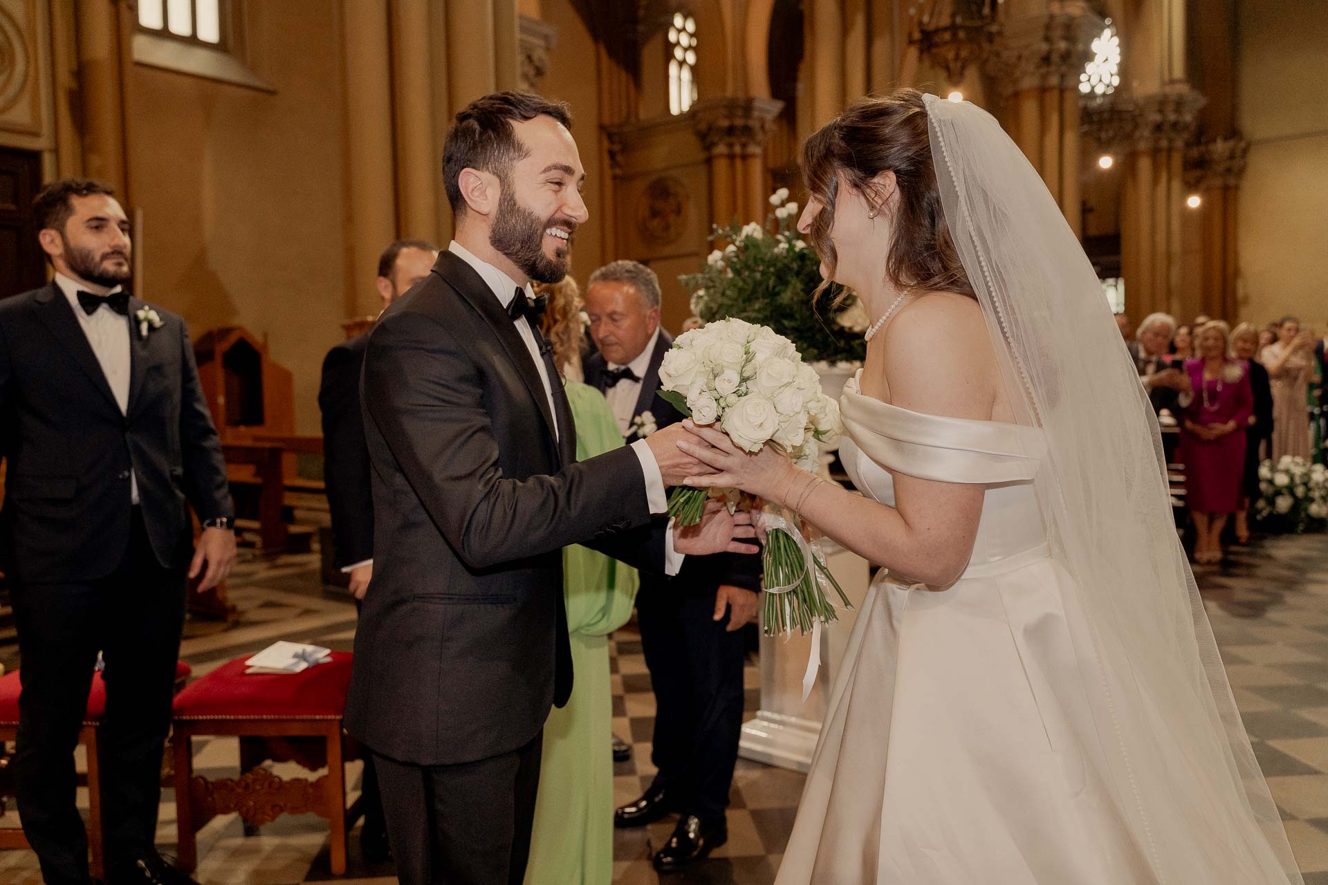Lo sposo consegna il bouquet alla sposa davanti all'altare