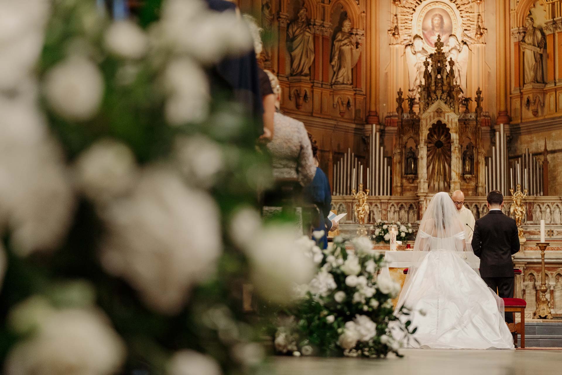 Gli sposi all'altare, visti tra i fiori bianchi