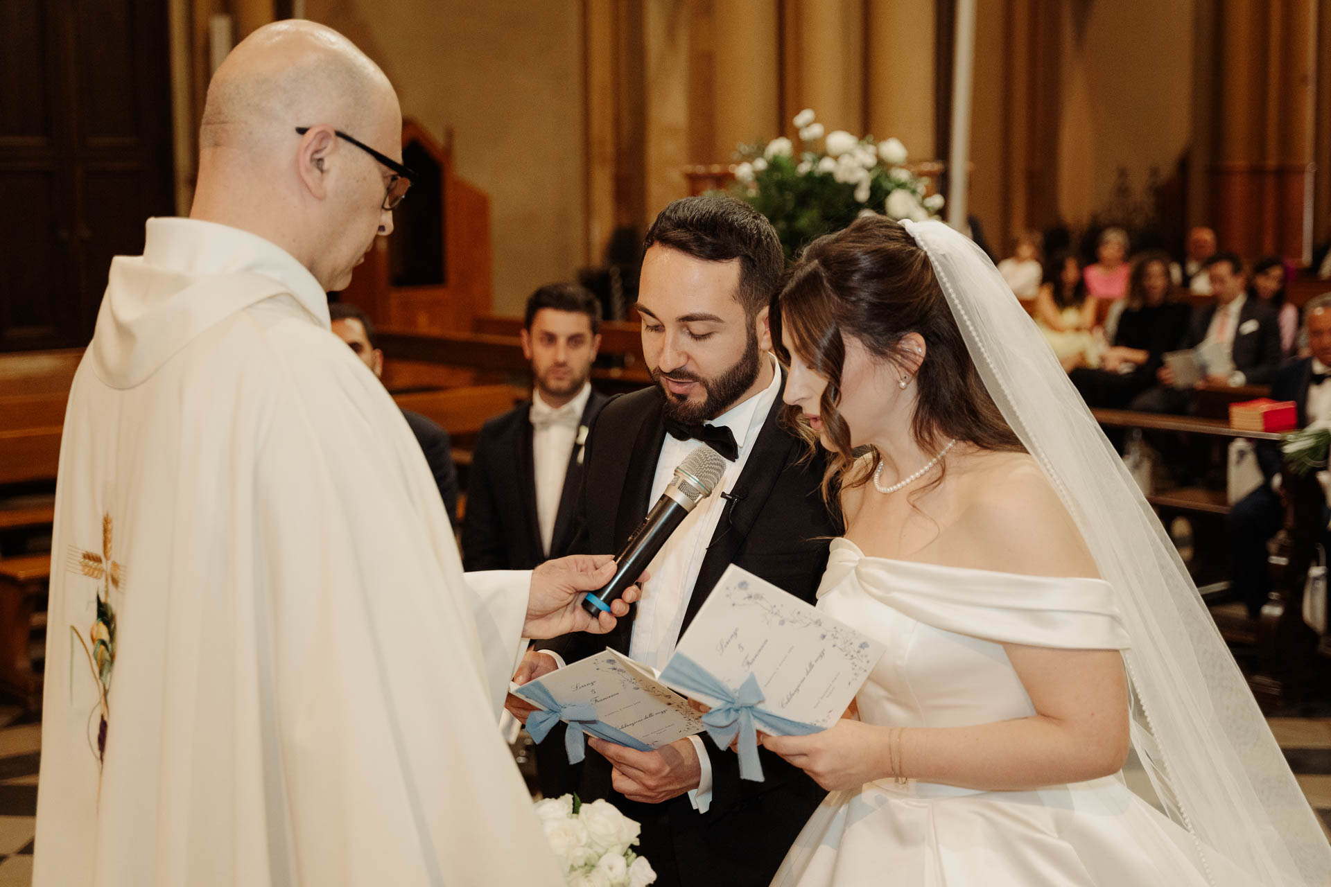 Il celebrante tiene il microfono mentre gli sposi leggono