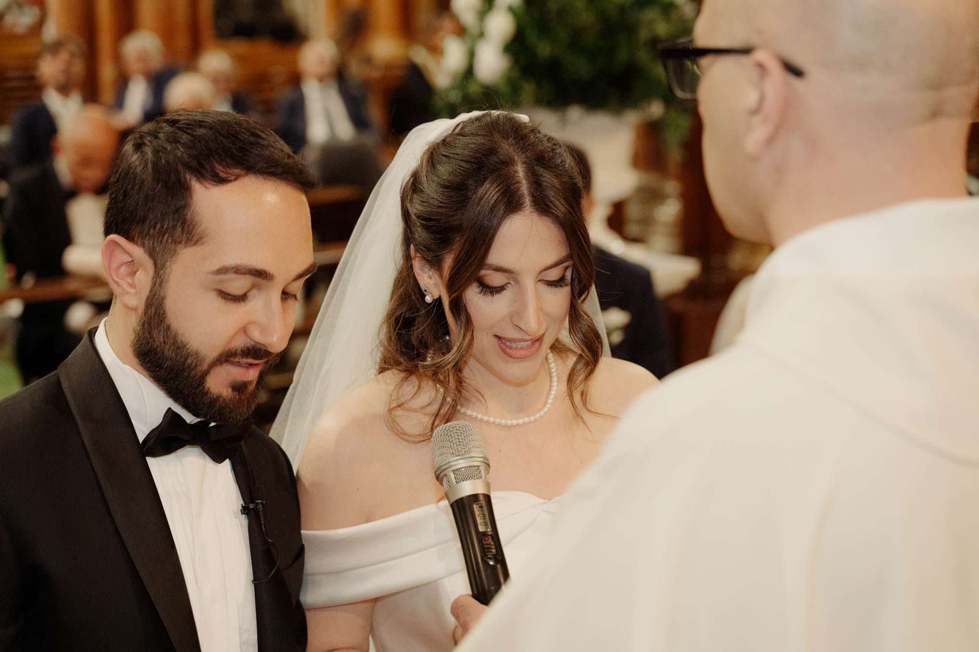 Gli sposi leggono le promesse davanti al celebrante, da vicino