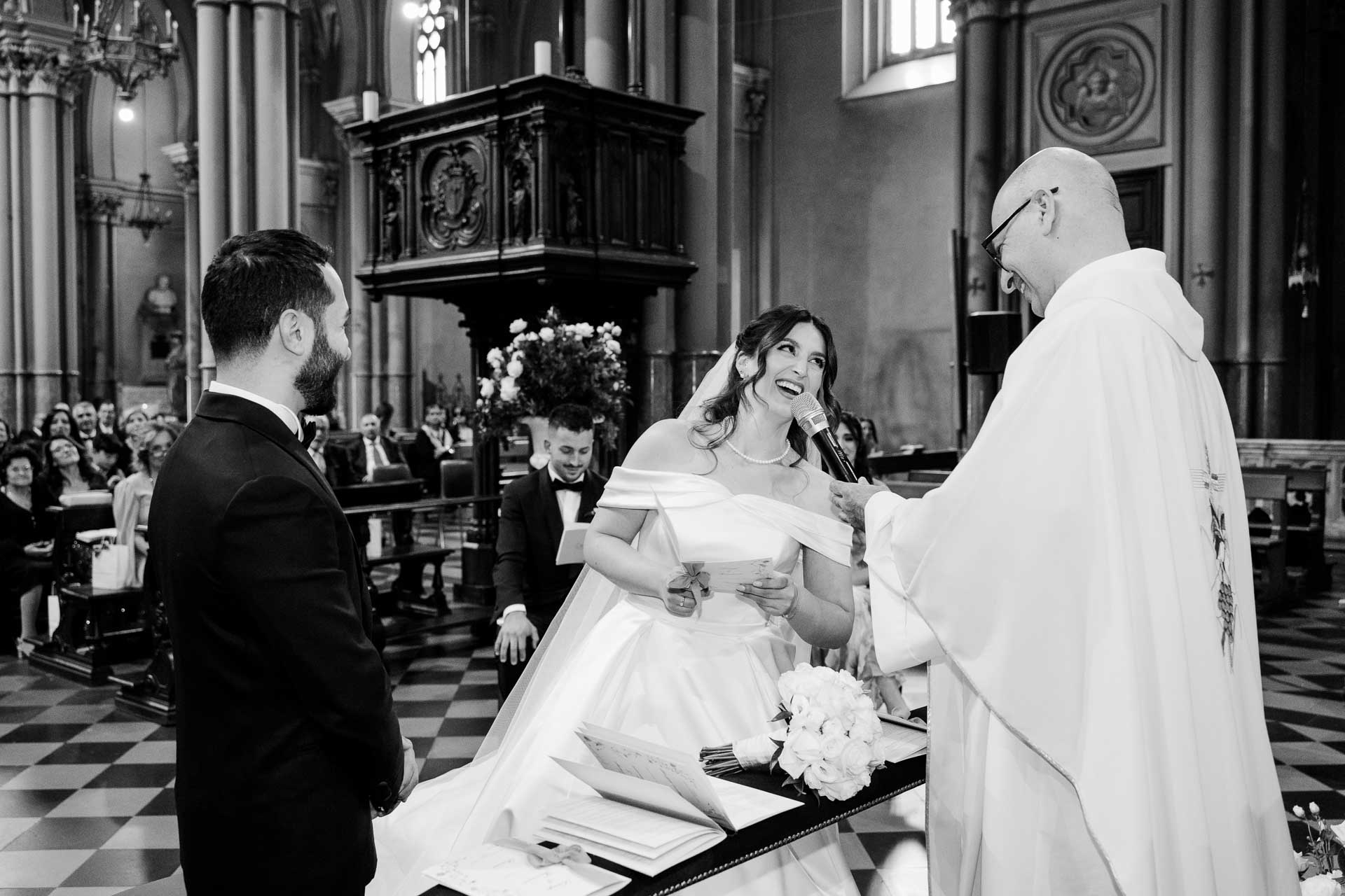 In bianco e nero, la sposa ride leggendo le promesse
