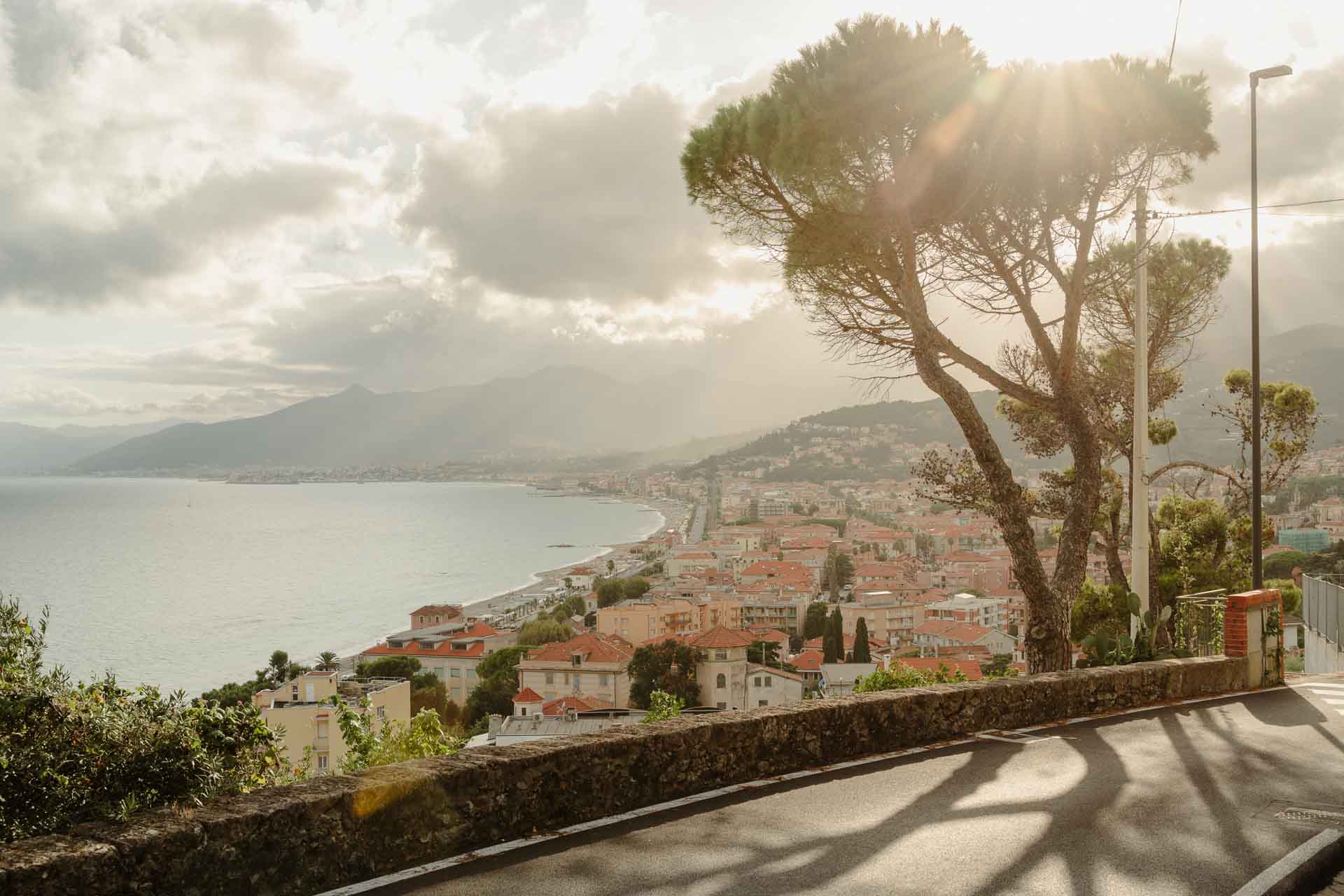 Il golfo di Finale Ligure dalla strada in collina, con un pino controluce sopra il mare