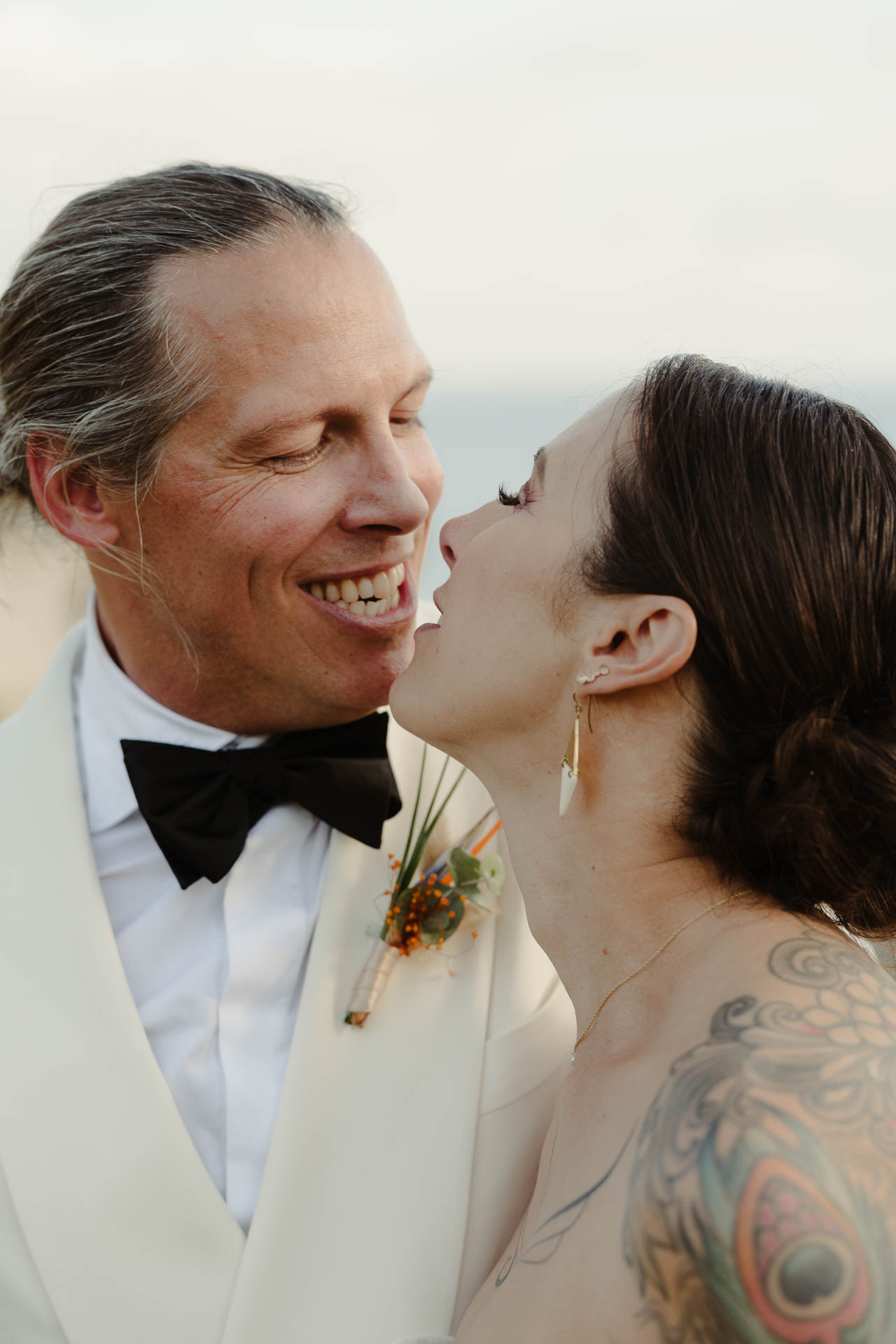 Lo sposo ride mentre la sposa lo bacia sulla guancia