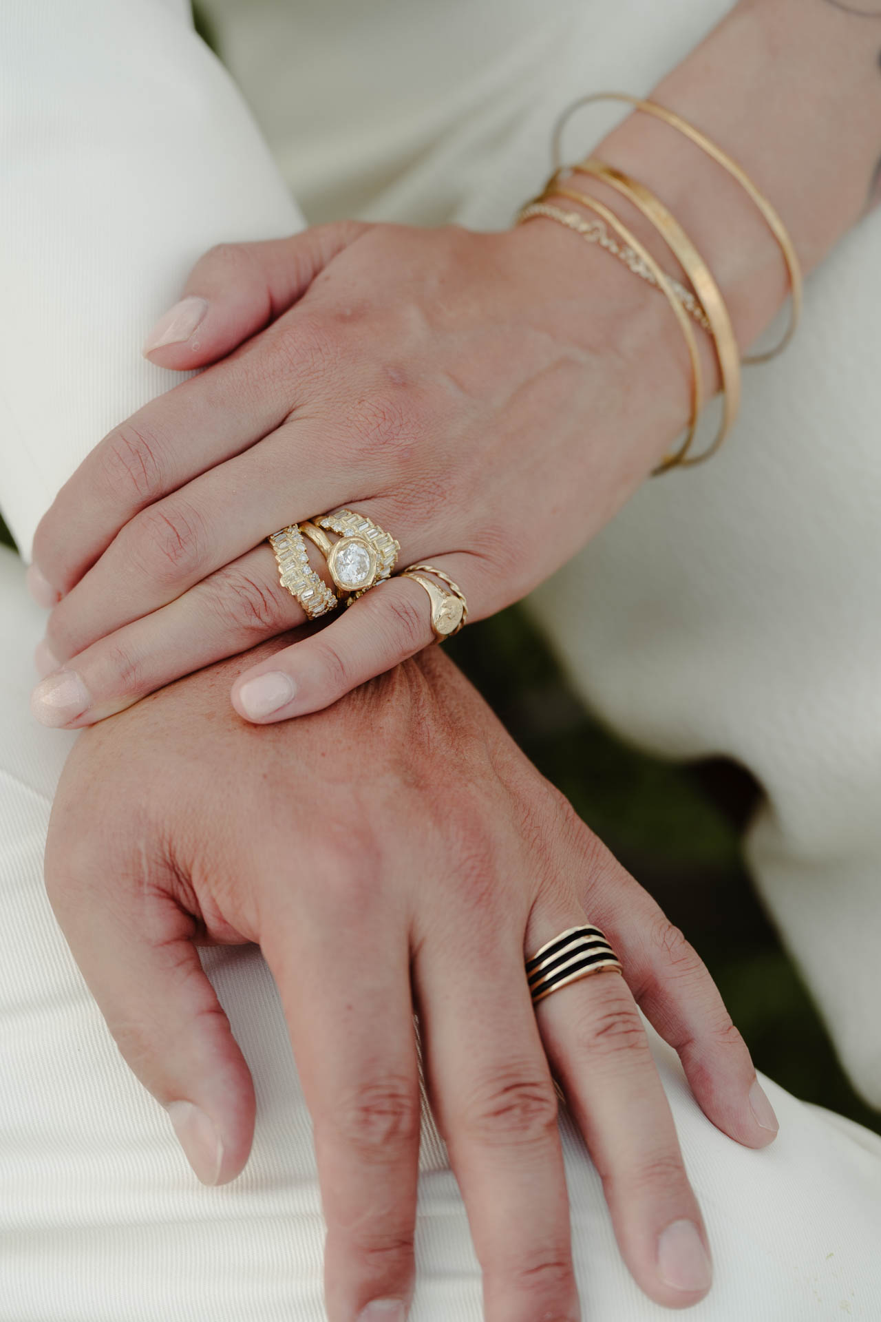 Le mani degli sposi con le fedi e i bracciali dorati