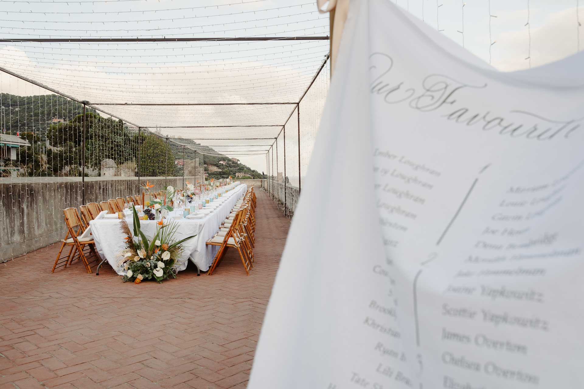 Il tableau di stoffa con i nomi degli invitati e la tavolata sulla terrazza