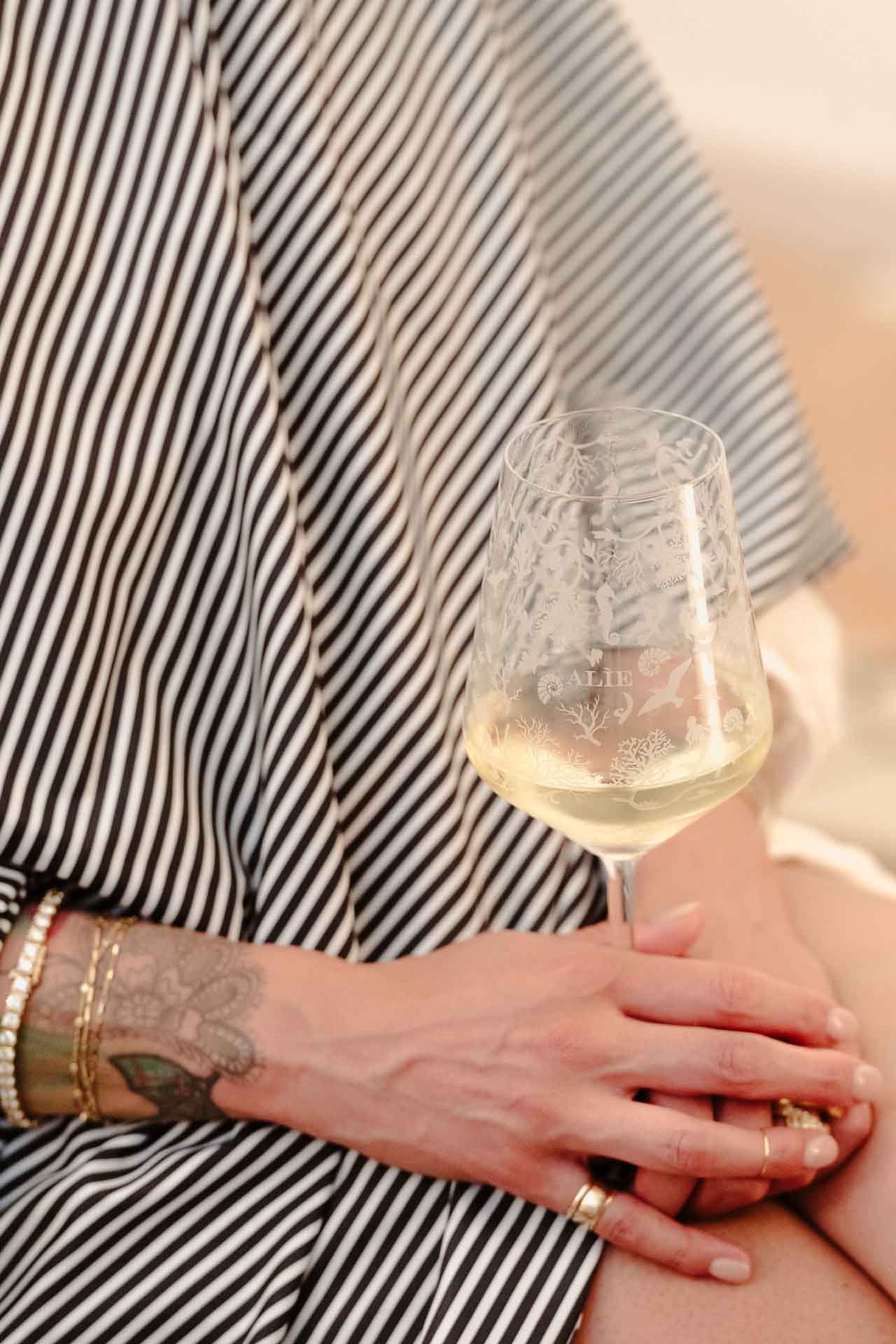 La sposa con un calice in mano, avvolta nella mantellina a righe