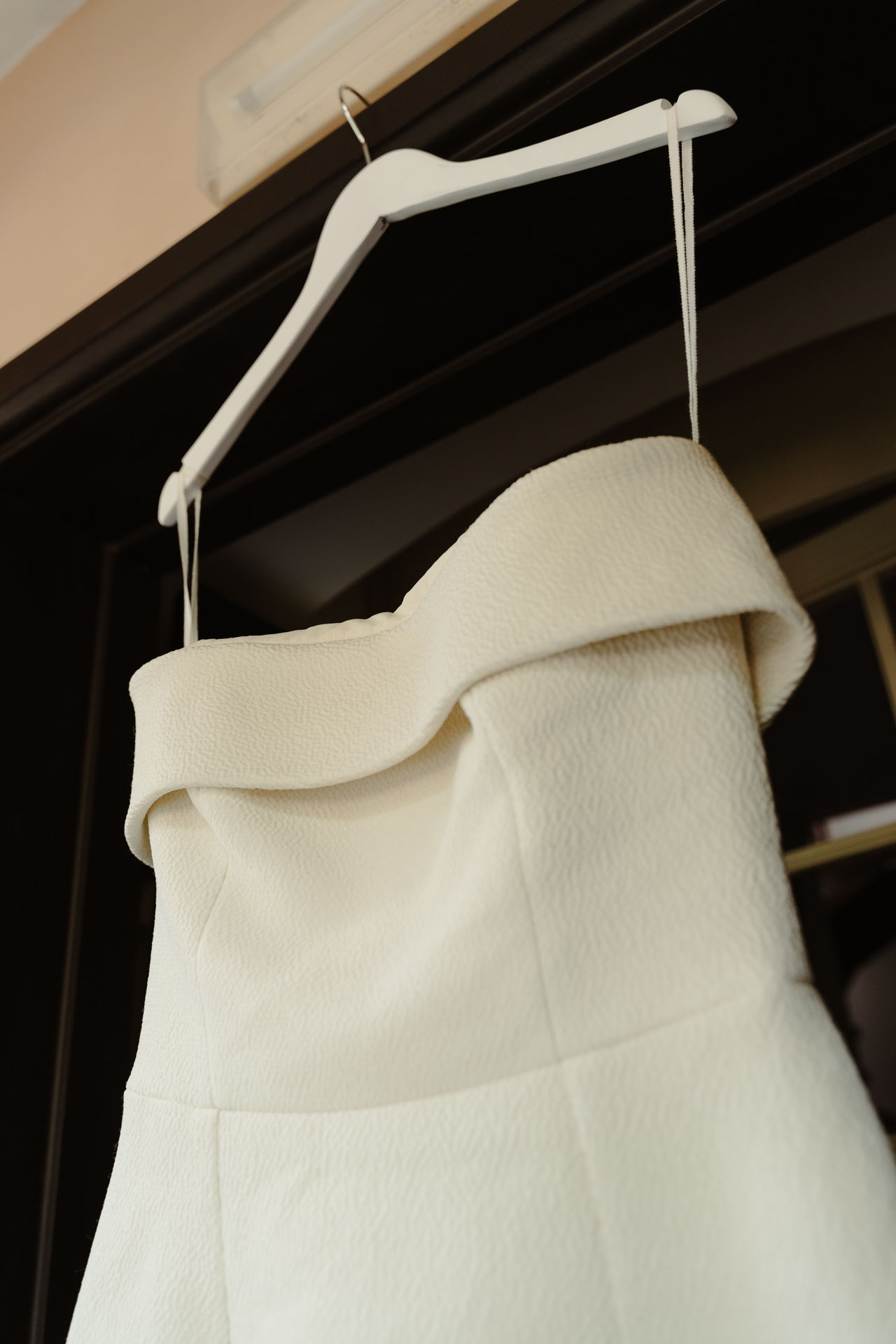 L'abito della sposa appeso, con la scollatura a fascia