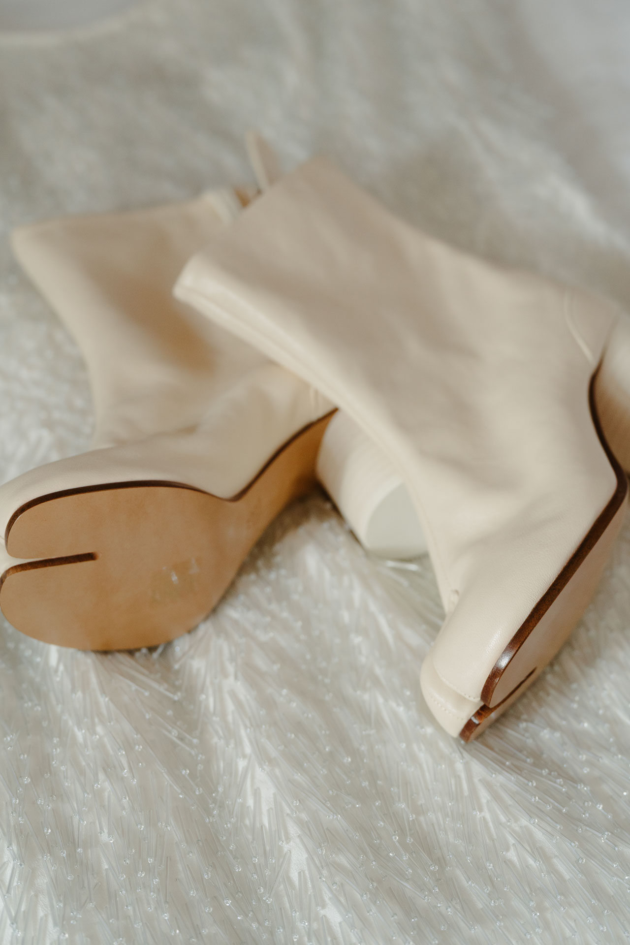 Gli stivaletti color avorio della sposa sul copriletto