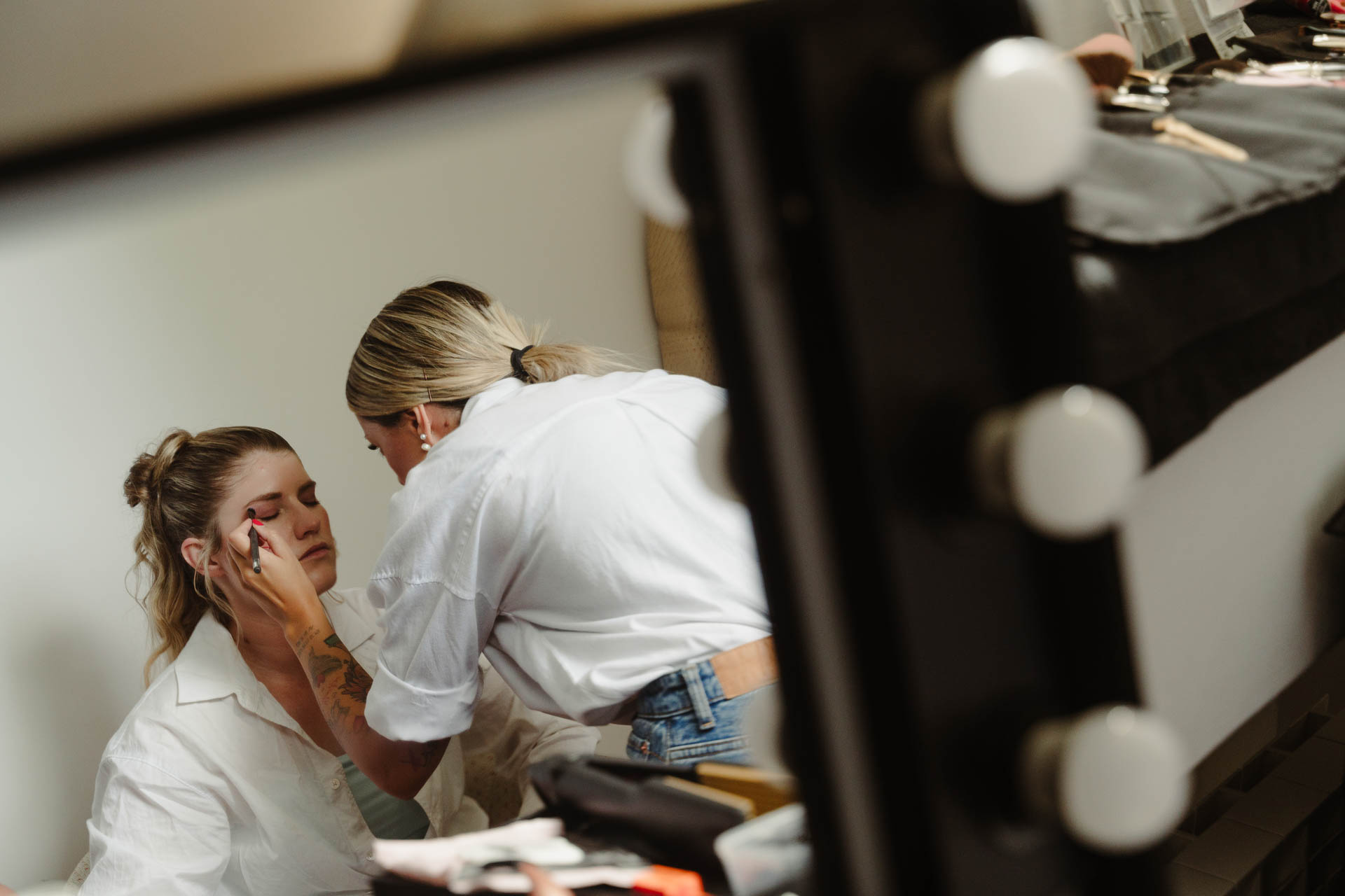 Nello specchio con le lampadine, il trucco di un'amica della sposa