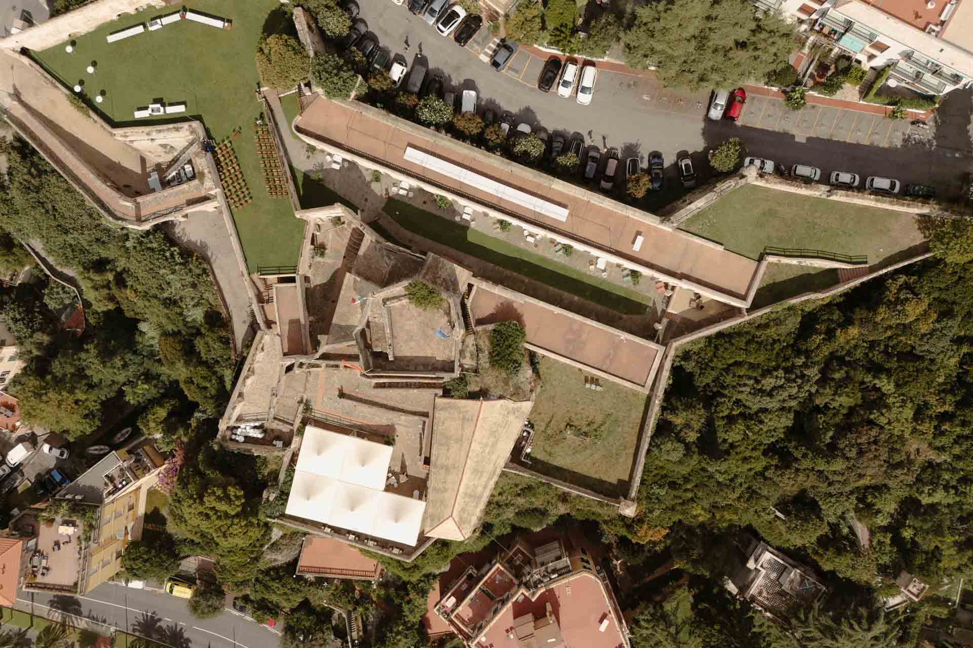 Veduta aerea a picco sulla Fortezza di Castelfranco, a Finale Ligure, con il prato pronto per la cerimonia