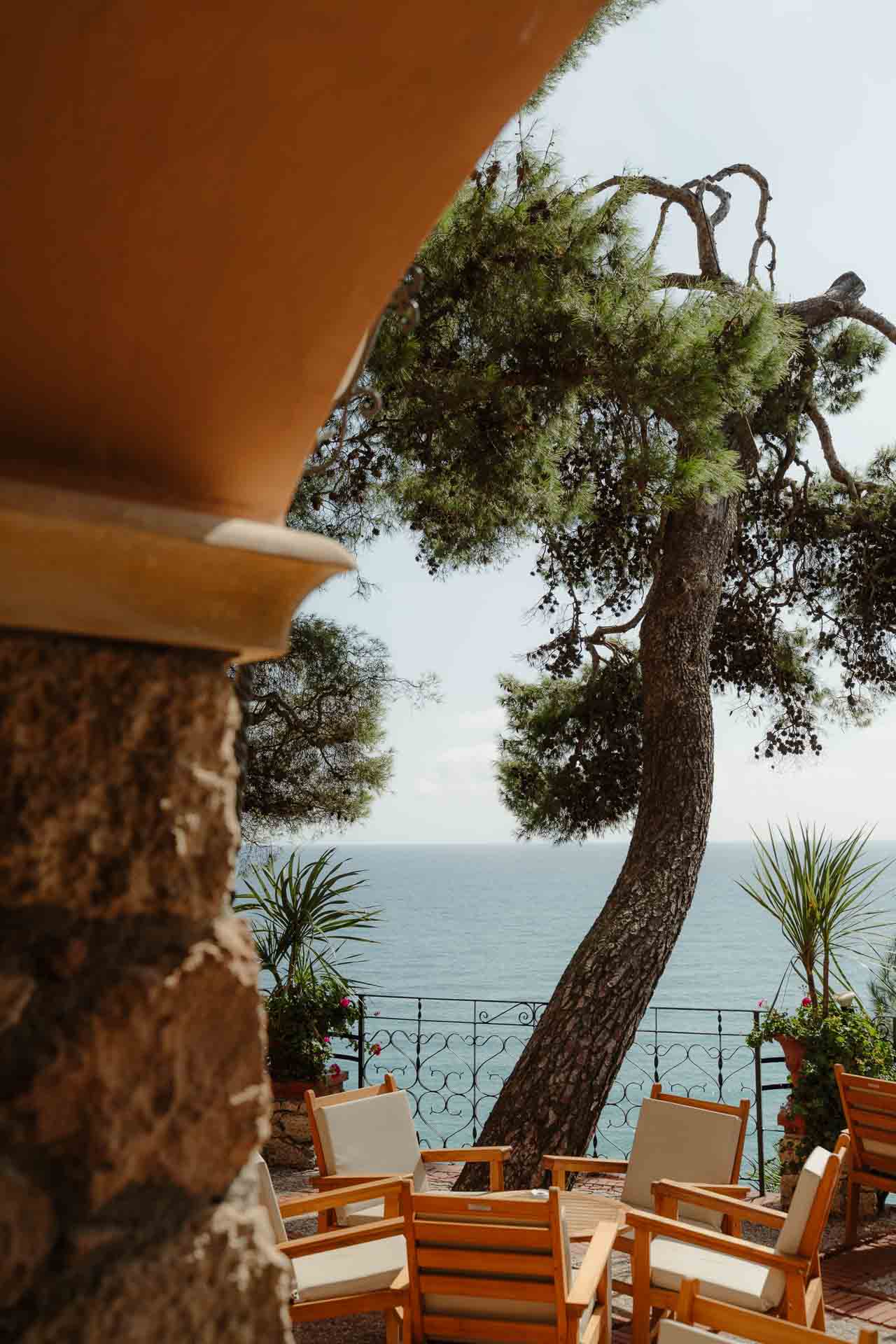 Dalla terrazza, un pino sul mare e le sedie di legno