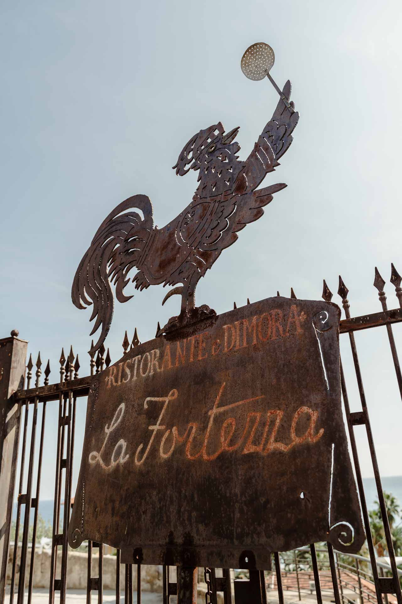 L'insegna in ferro della Fortezza, con il gallo sopra il cancello
