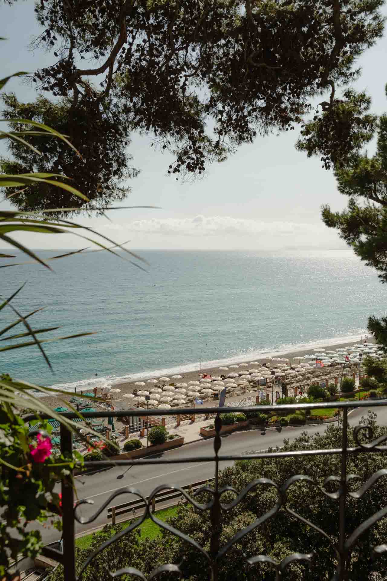 Il mare e la spiaggia tra i rami dei pini, dalla terrazza
