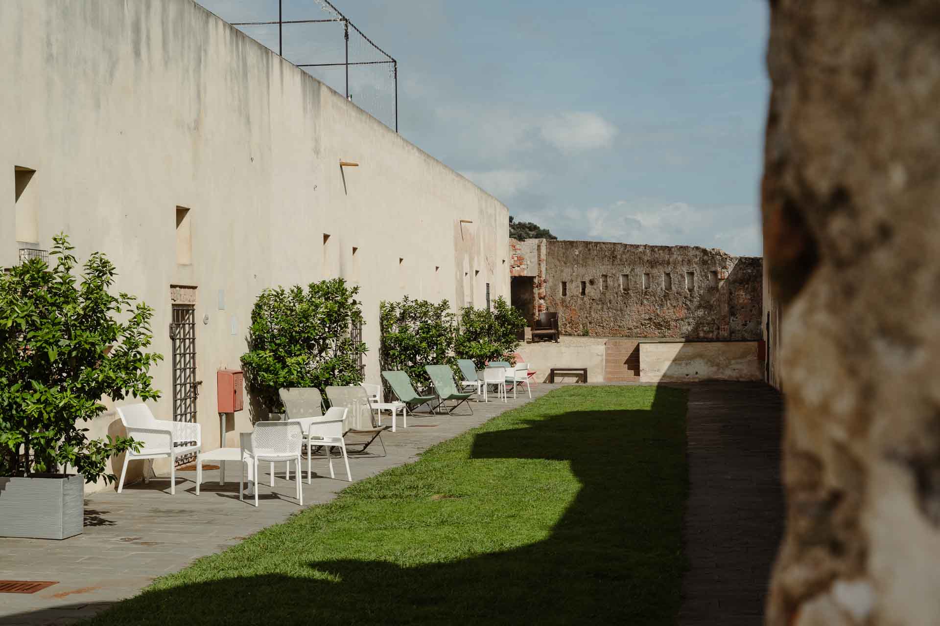 Il giardino della fortezza con le sedie bianche lungo le mura