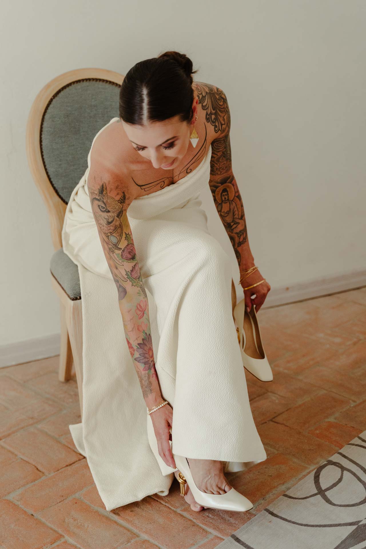 La sposa infila le scarpe, seduta su una sedia