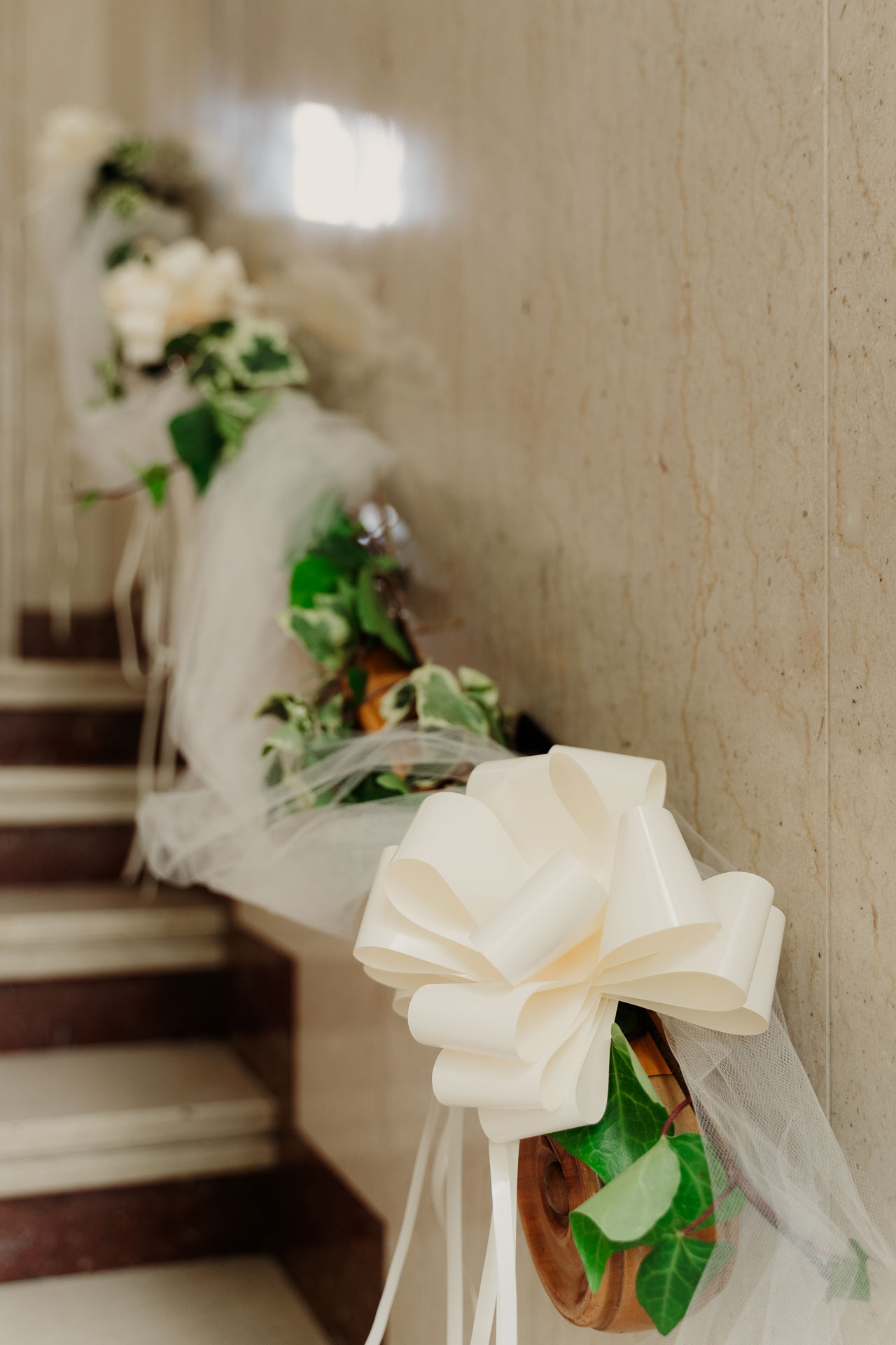 Il fiocco bianco e i fiori sul corrimano della scala di casa