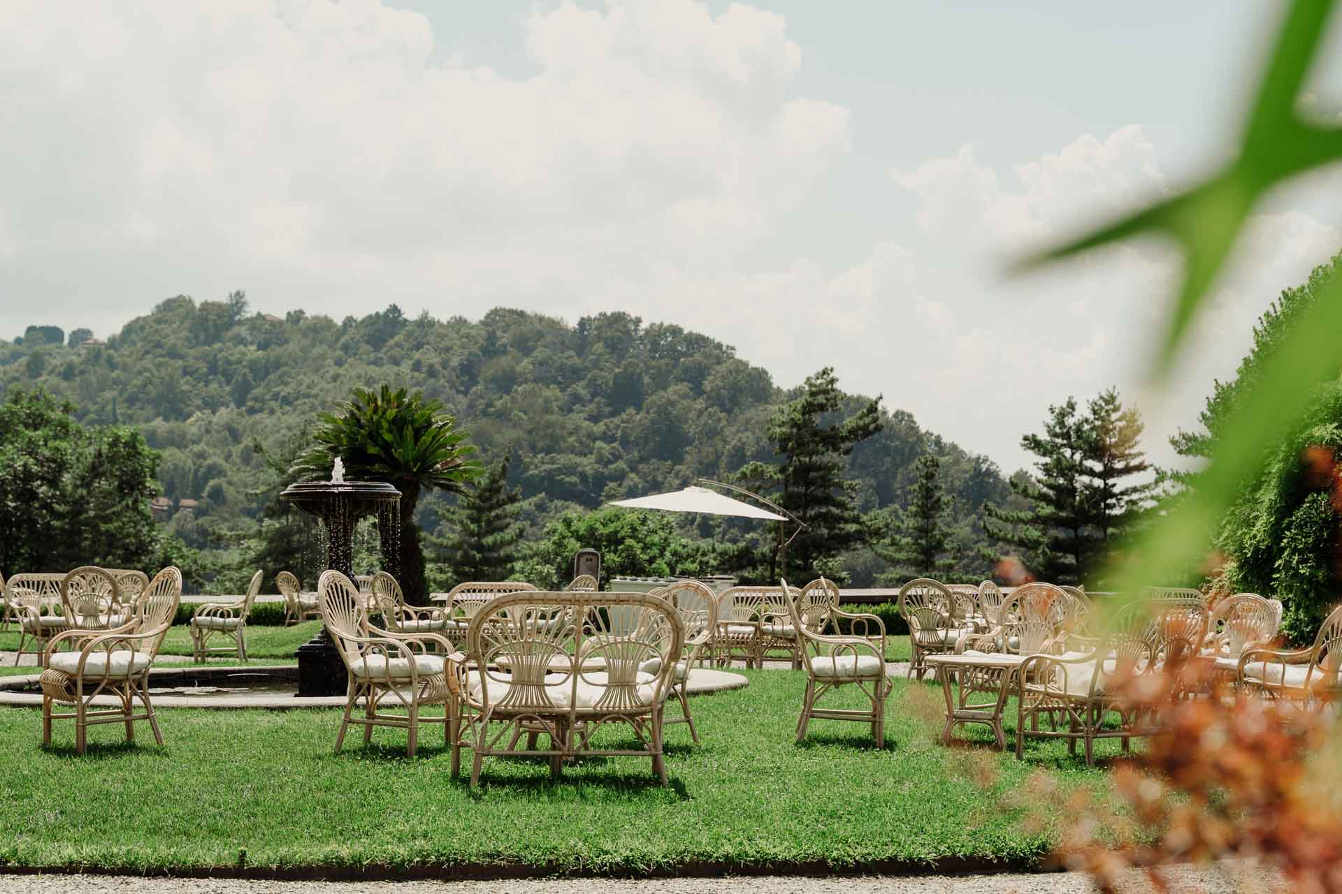 Le sedie di vimini sul prato del giardino di Villa Cimena, con le colline sullo sfondo