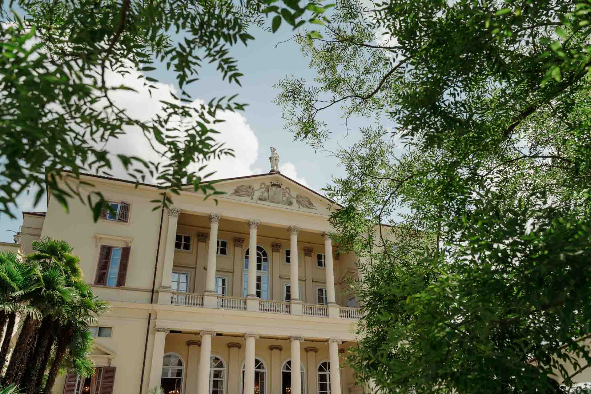 La facciata gialla di Villa Cimena tra gli alberi del parco
