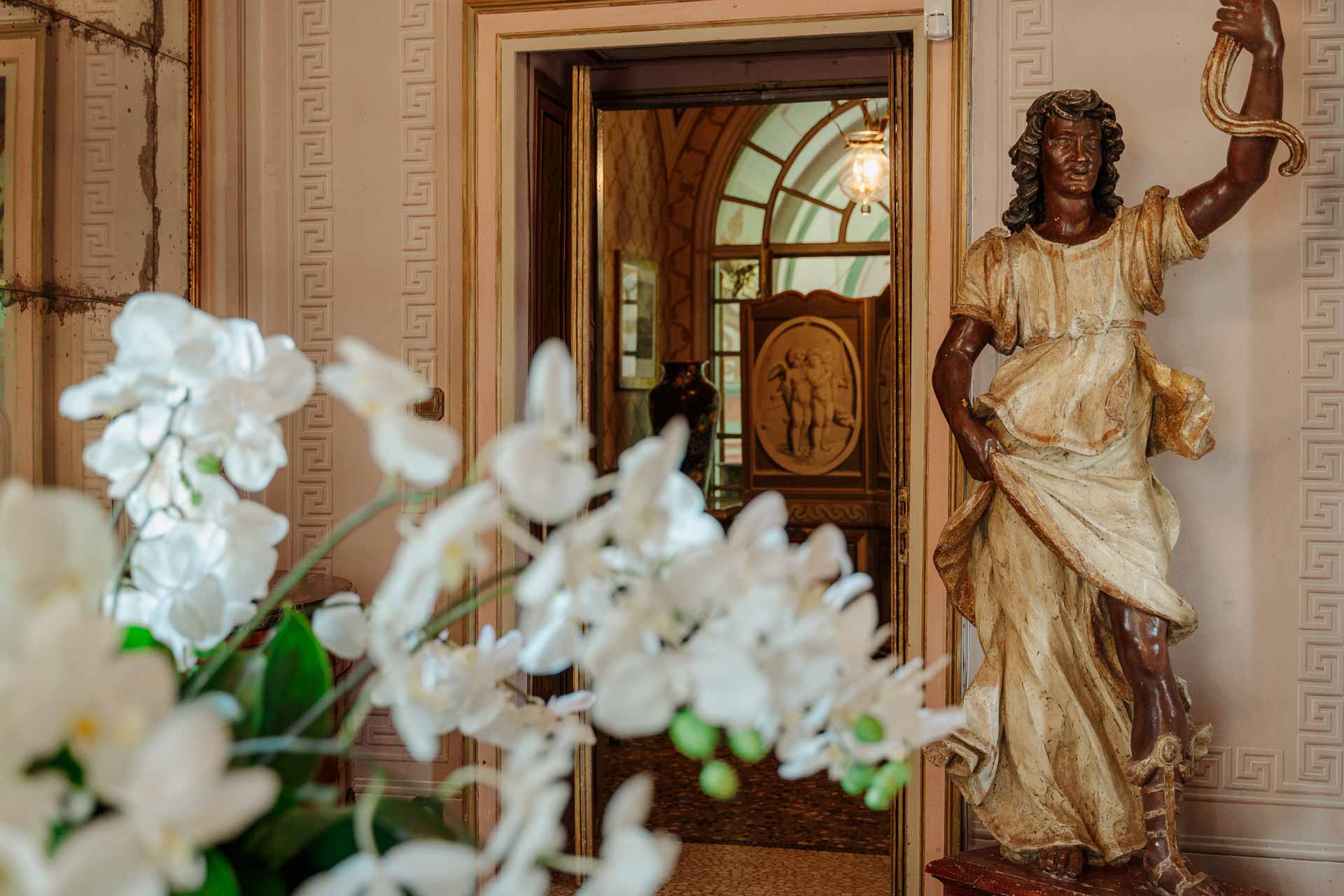 Orchidee bianche e una statua dorata nell'ingresso della villa