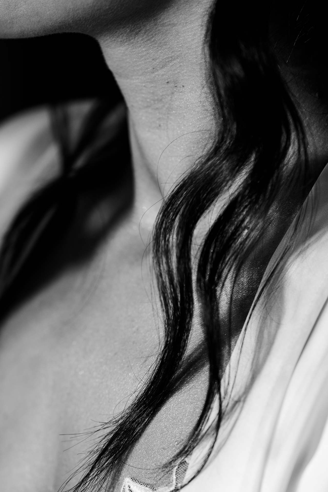 In bianco e nero, i capelli scuri della sposa sulla spalla