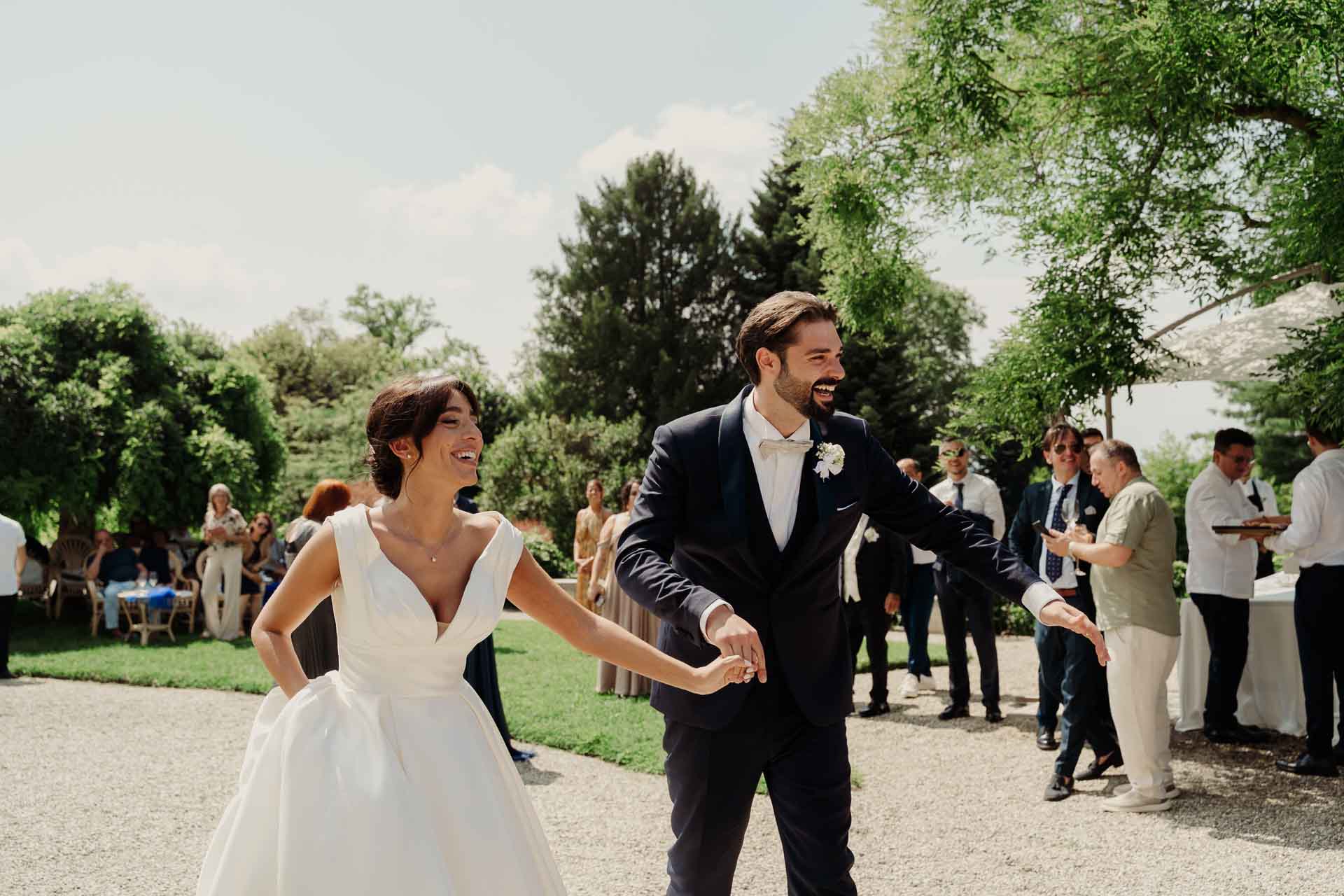 Gli sposi ridono mentre vanno incontro agli invitati nel giardino