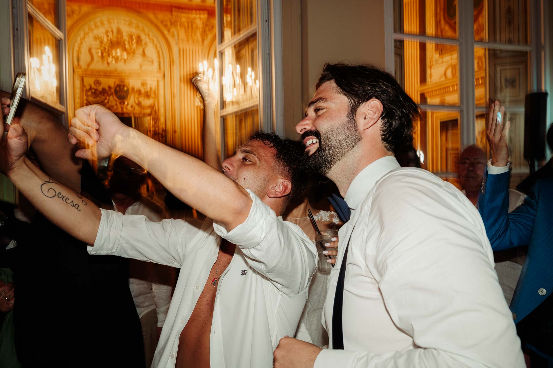 Lo sposo ride a testa indietro tra gli amici, uno con il braccio teso