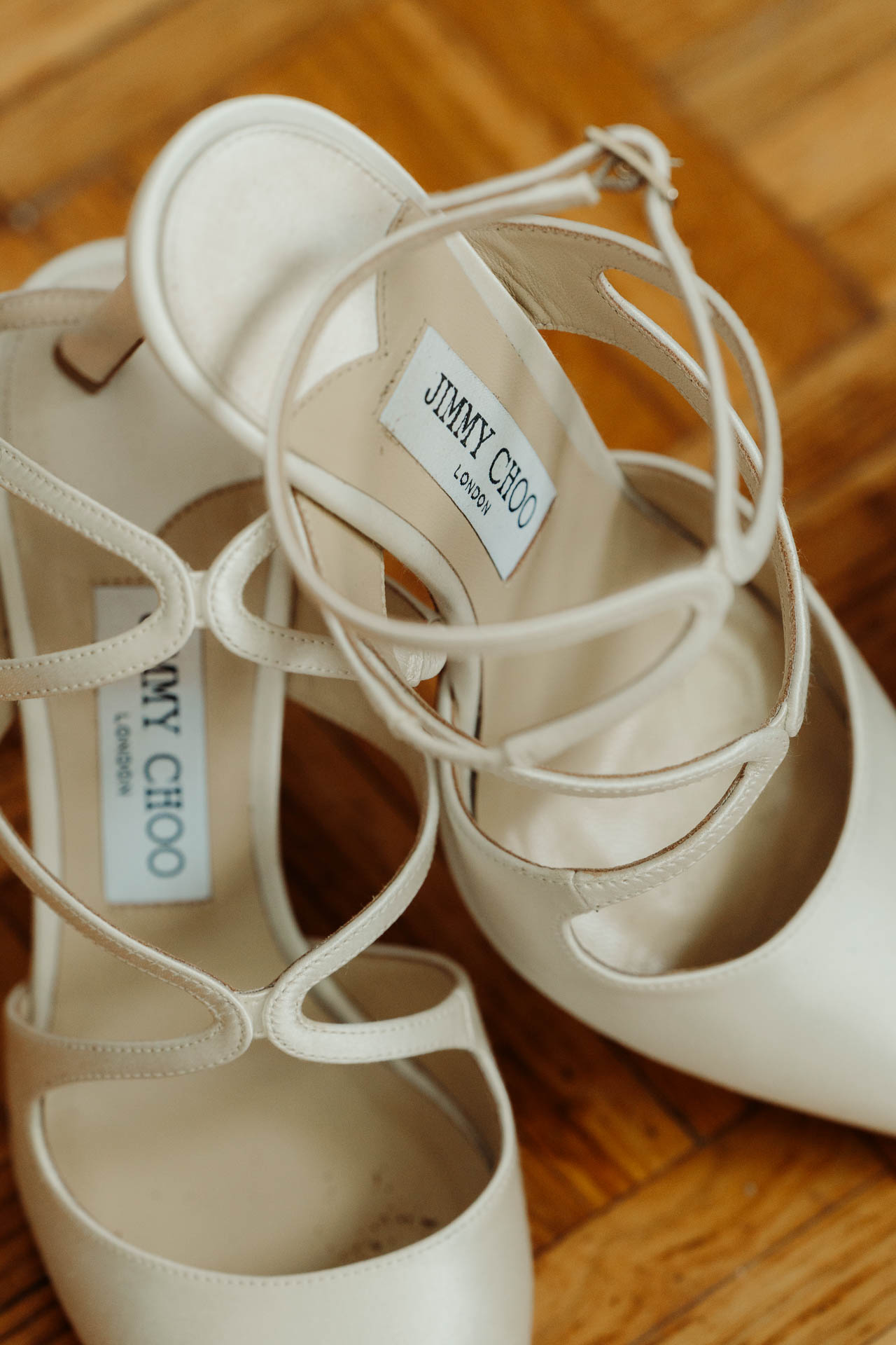 Le scarpe bianche con i lacci incrociati, sul parquet