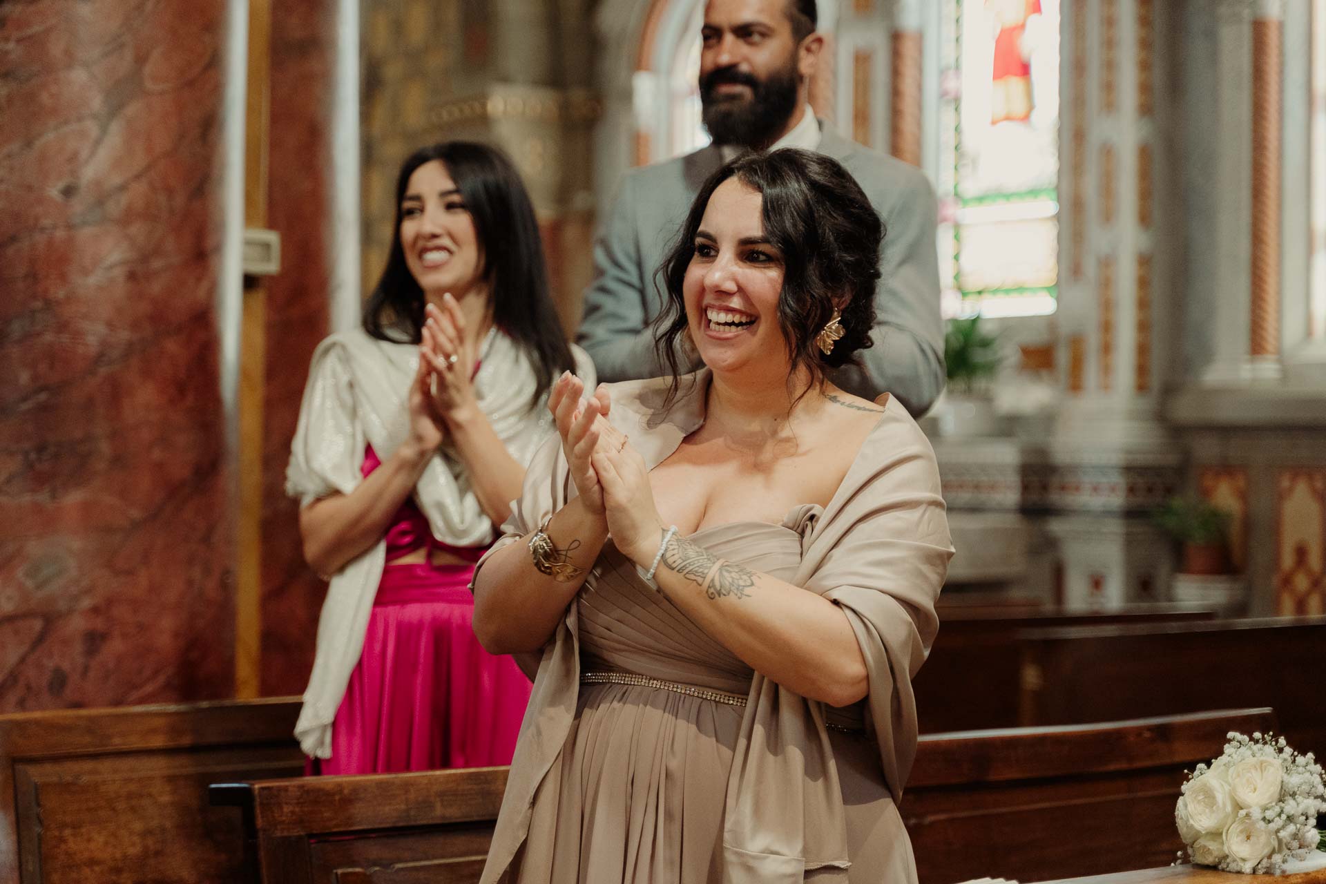 Due invitate applaudono sorridendo nel banco