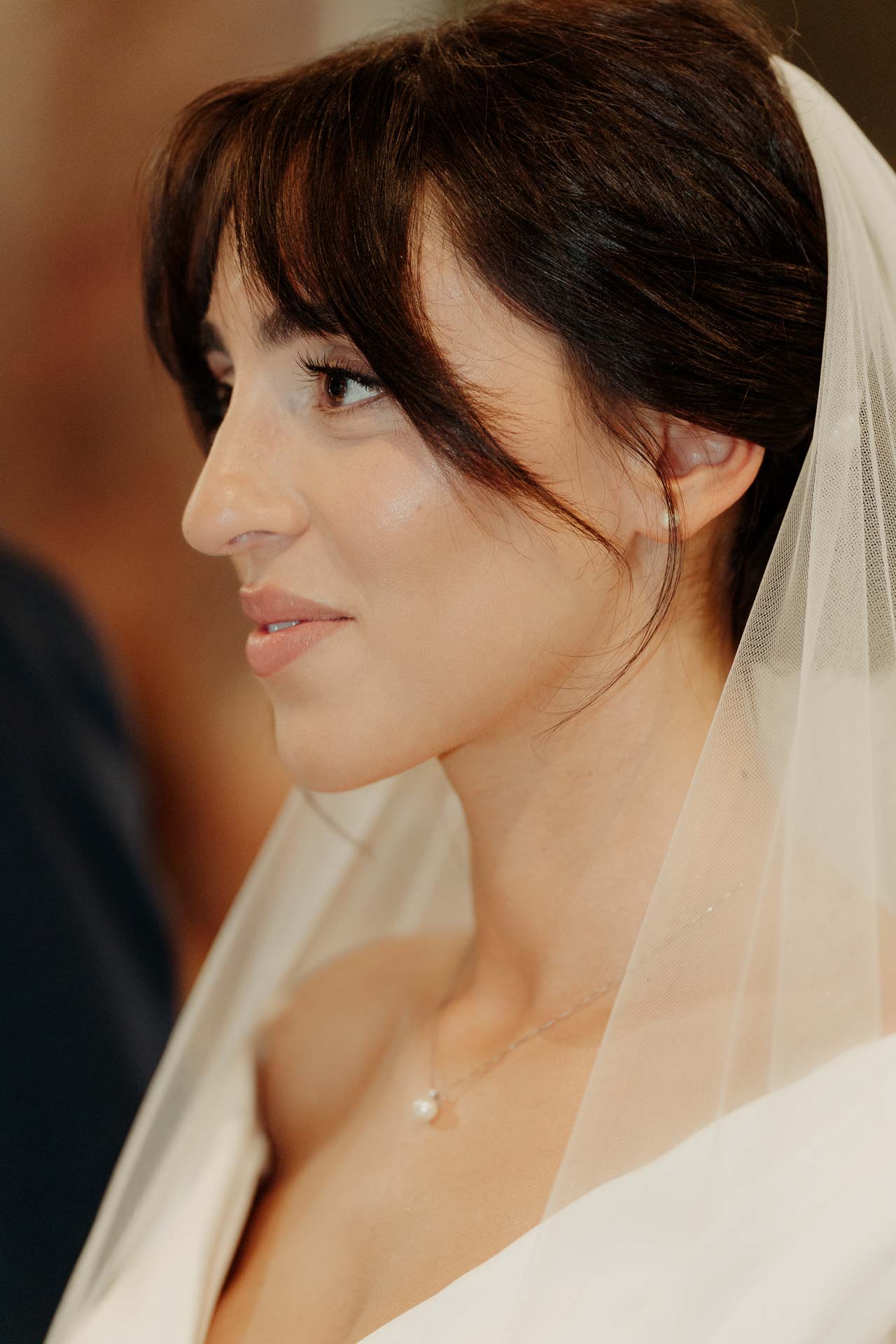 Ritratto della sposa di profilo, con il velo e una collana sottile