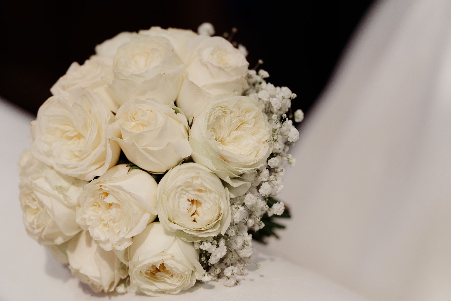 Il bouquet di rose bianche e gypsophila, poggiato sul velo