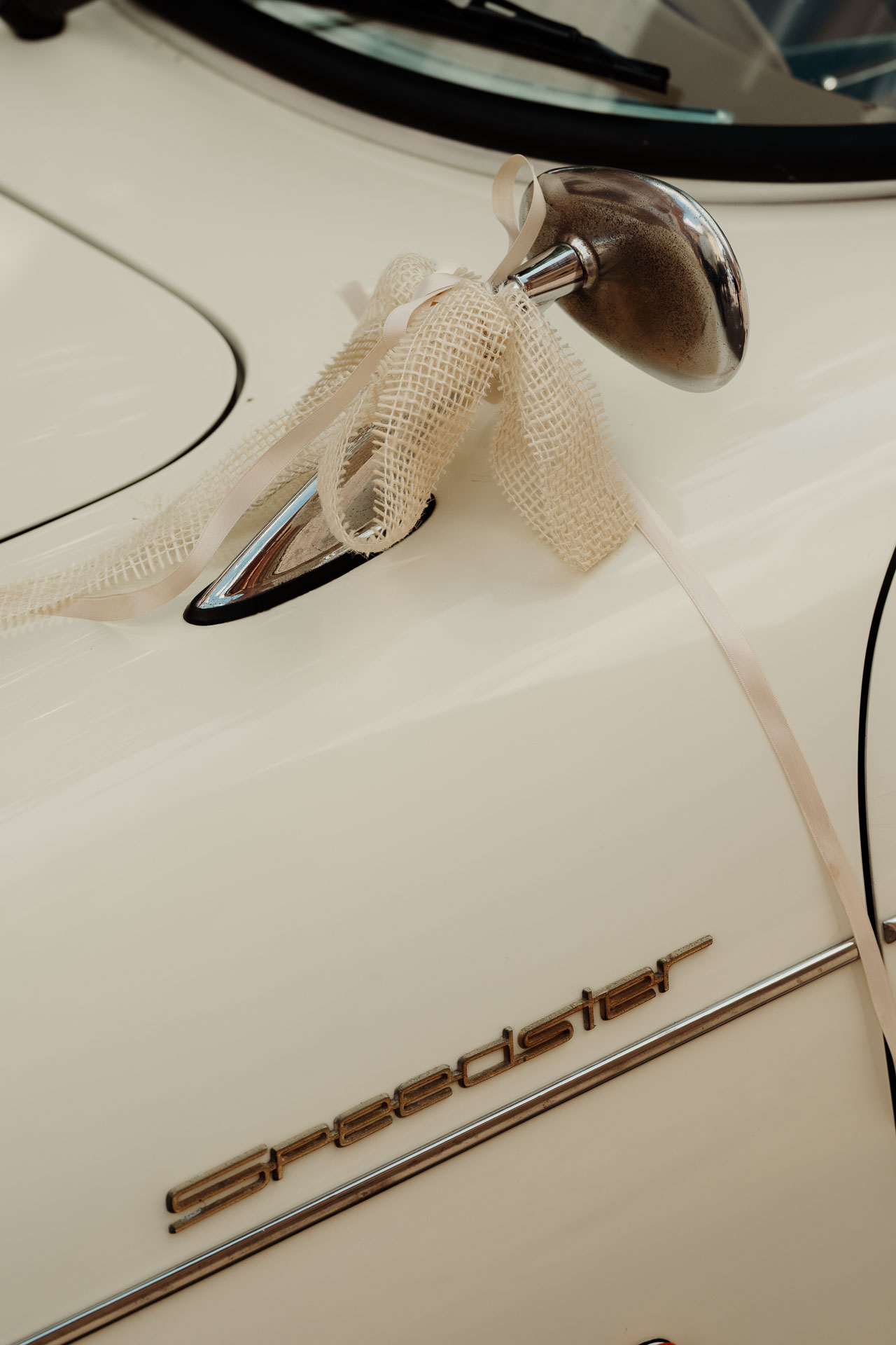 La maniglia dell'auto d'epoca bianca con il nastro, sopra la scritta Speedster