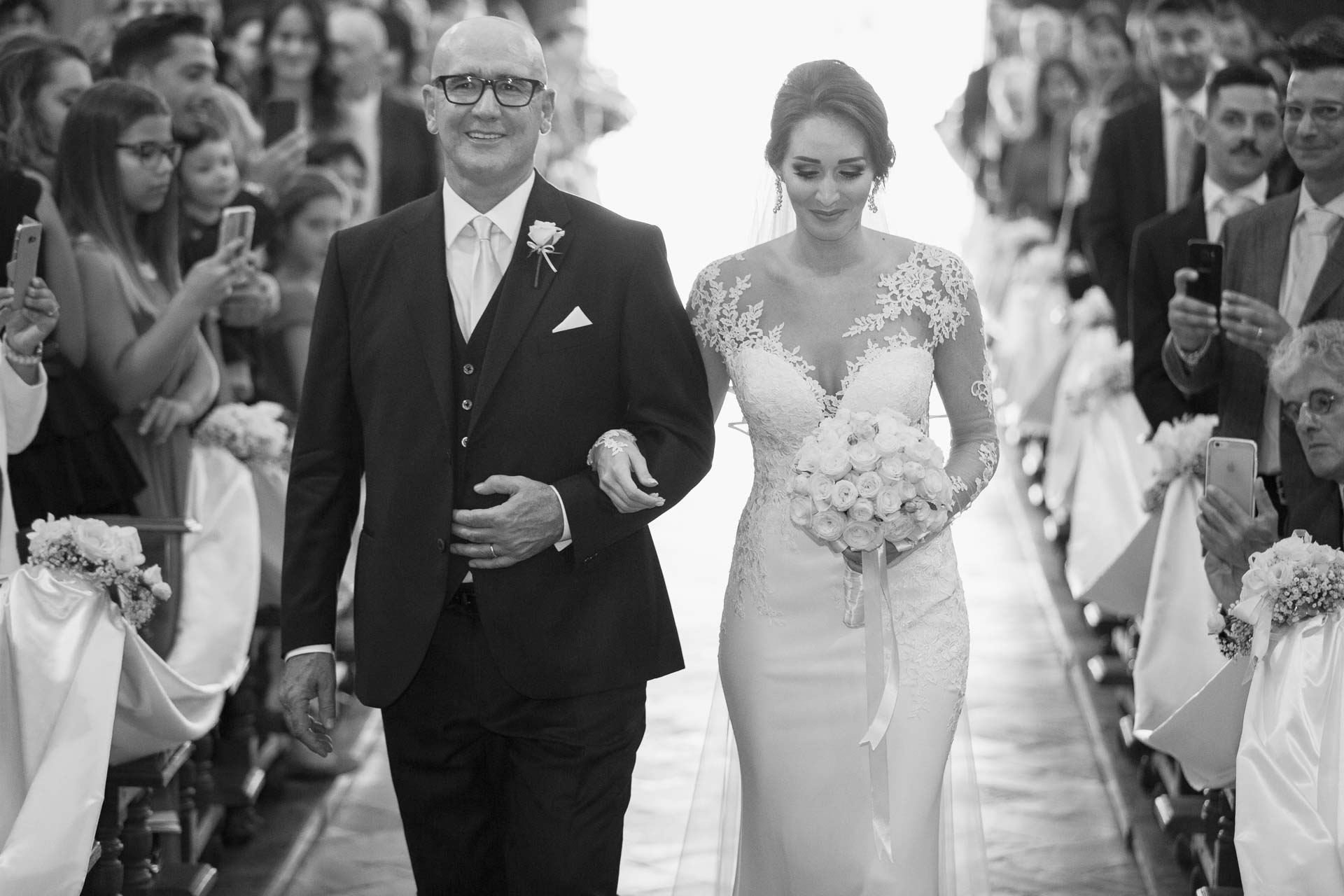 In bianco e nero, la sposa e il papà lungo la navata